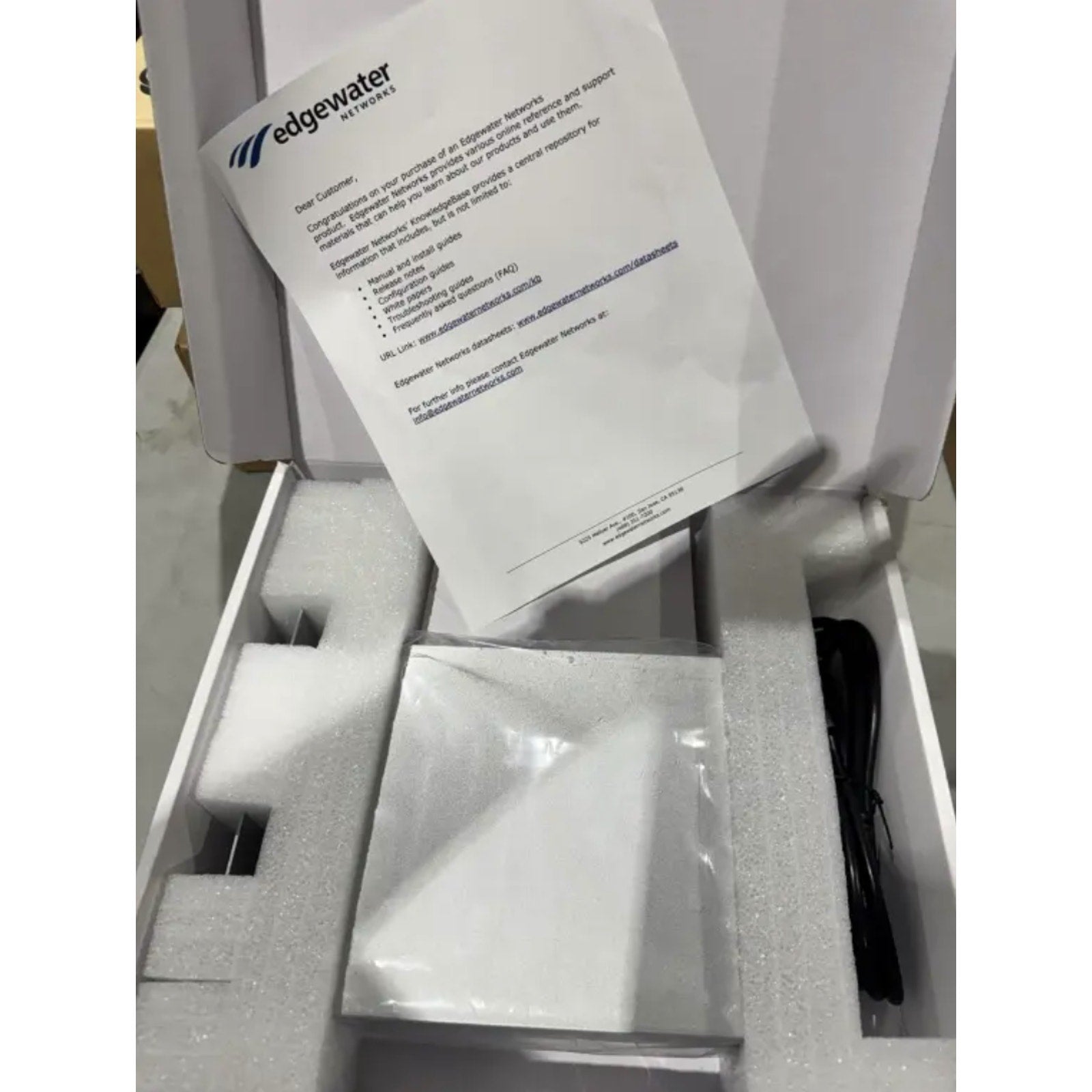Edgewater Networks 4550 Series Gateway Ethernet switch in open white box with manual and power cable foam padding
