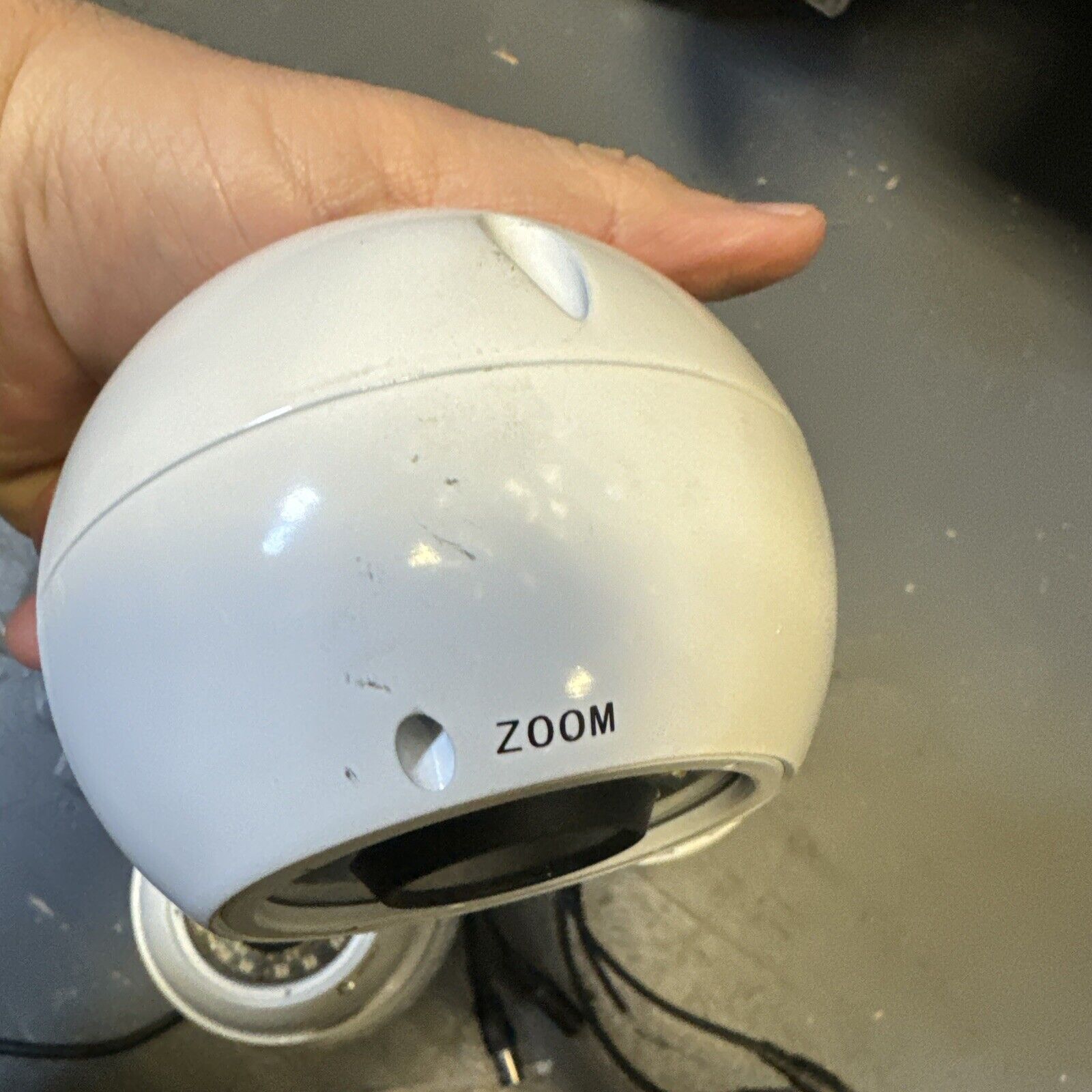 White SHIELD analog CCTV security dome camera with 3.6mm lens and zoom control held in hand close-up view