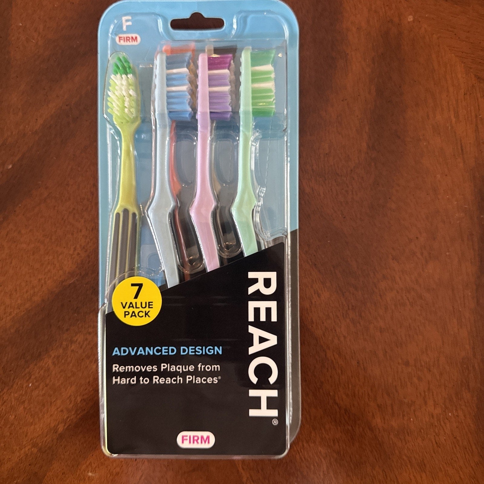 REACH Advanced Design adult toothbrush firm 7 count pack with multicolor handles and plaque removal claim
