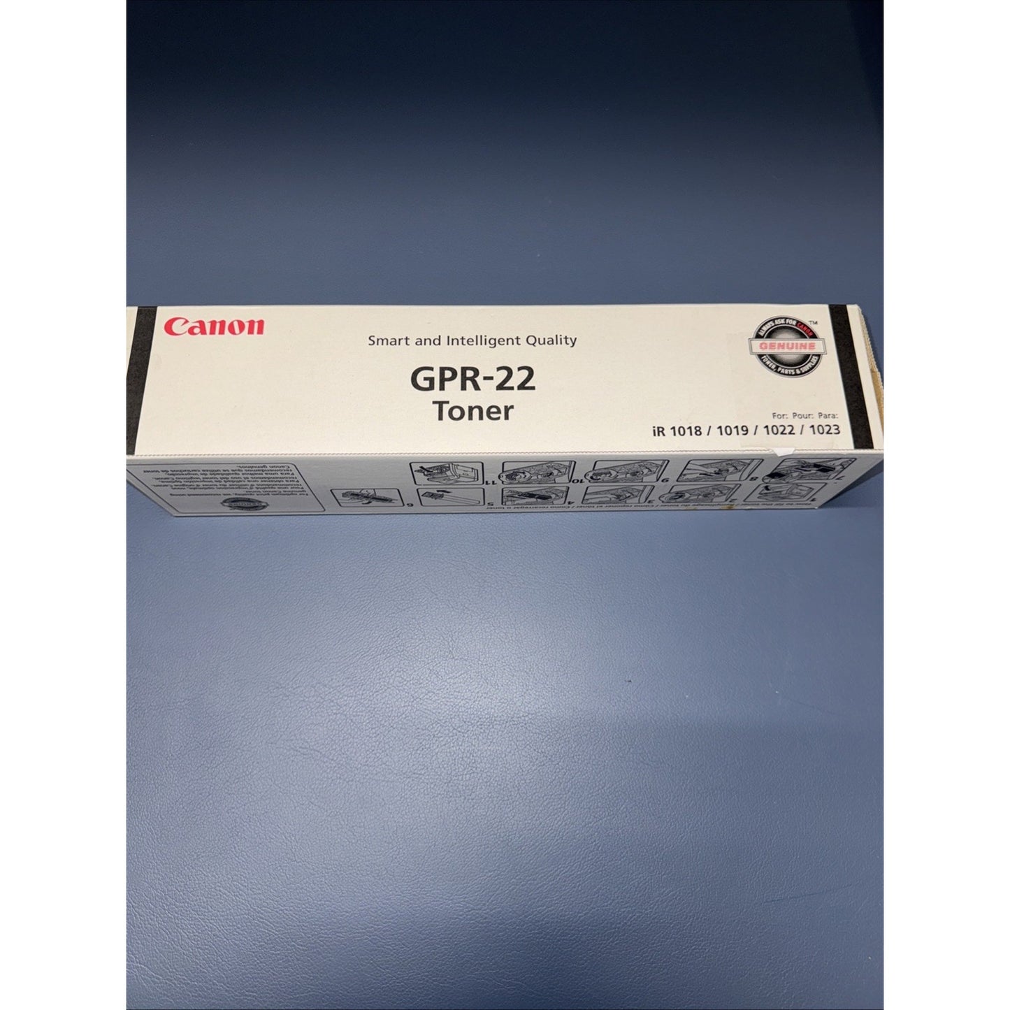 Canon GPR-22 toner cartridge box with branding and model information on a blue surface, showing compatibility with specific printer models and quality assurance seal.