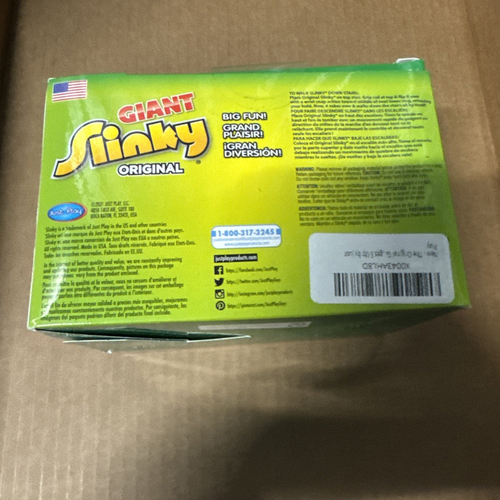 The Original Giant Slinky toy packaging box in green and yellow with product details and contact information visible