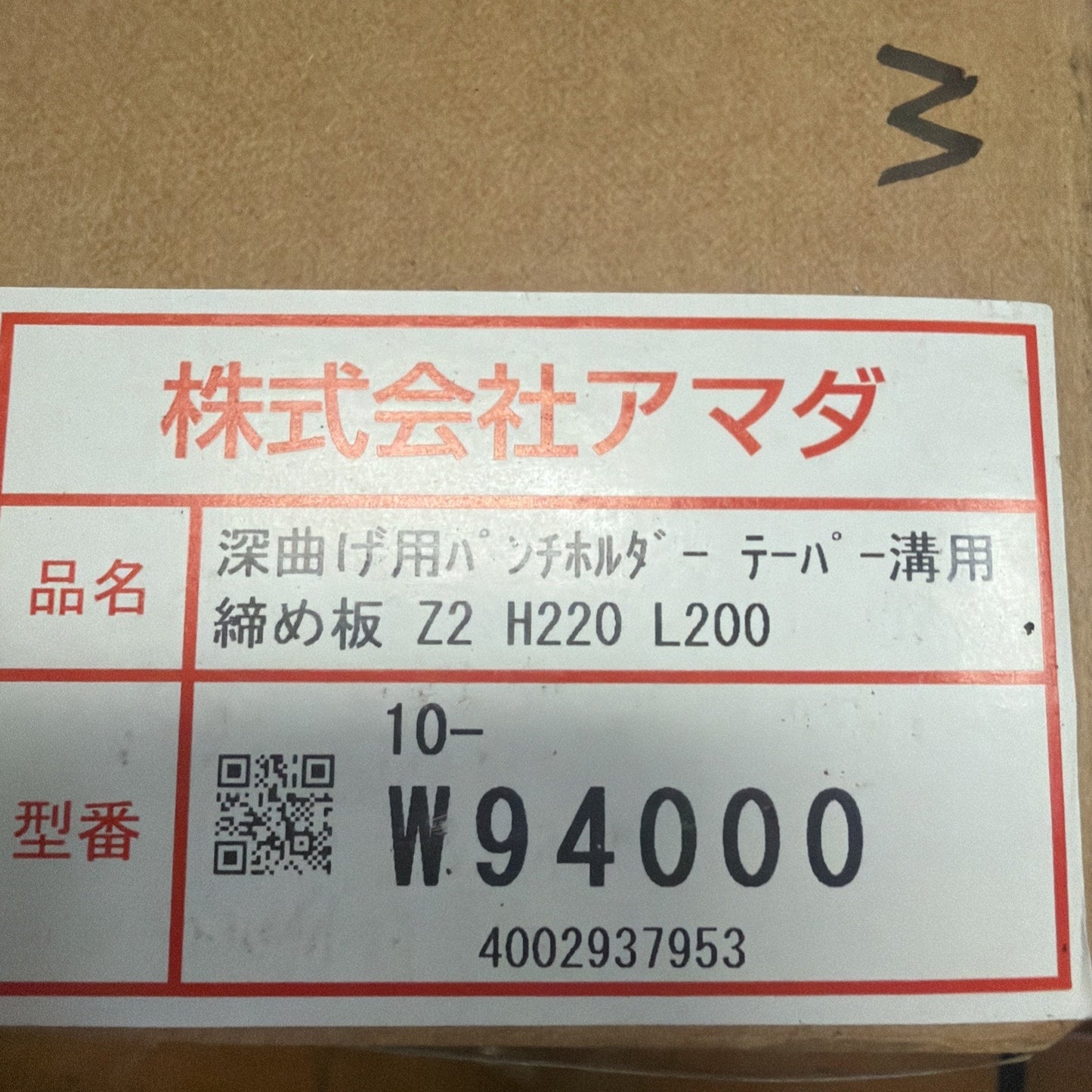 Close-up of a cardboard box label with red and black Japanese text, a QR code, and the model number W94000 printed in bold black letters.