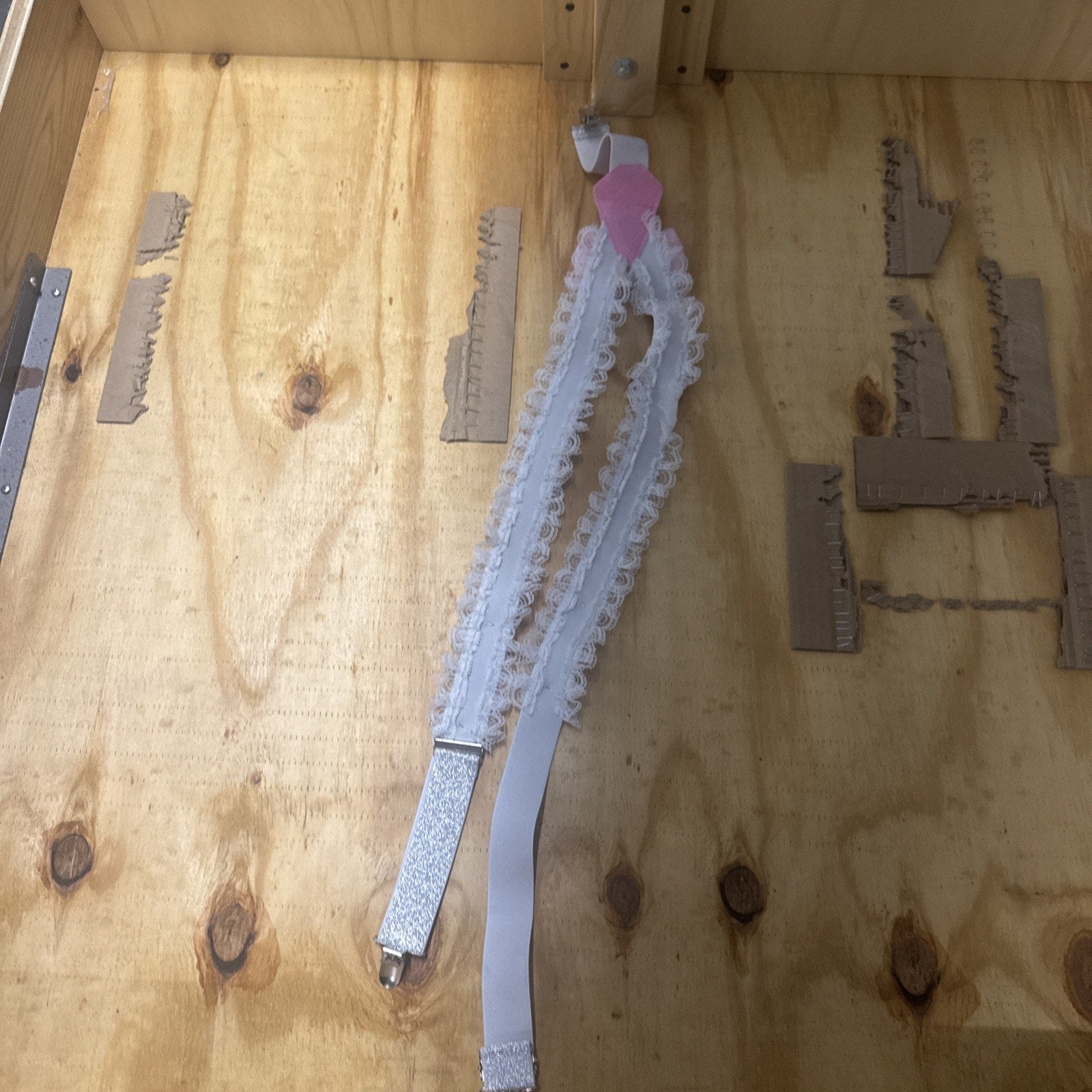 White lace bride future Mrs bachelorette party garter suspender with pink heart detail on wood background