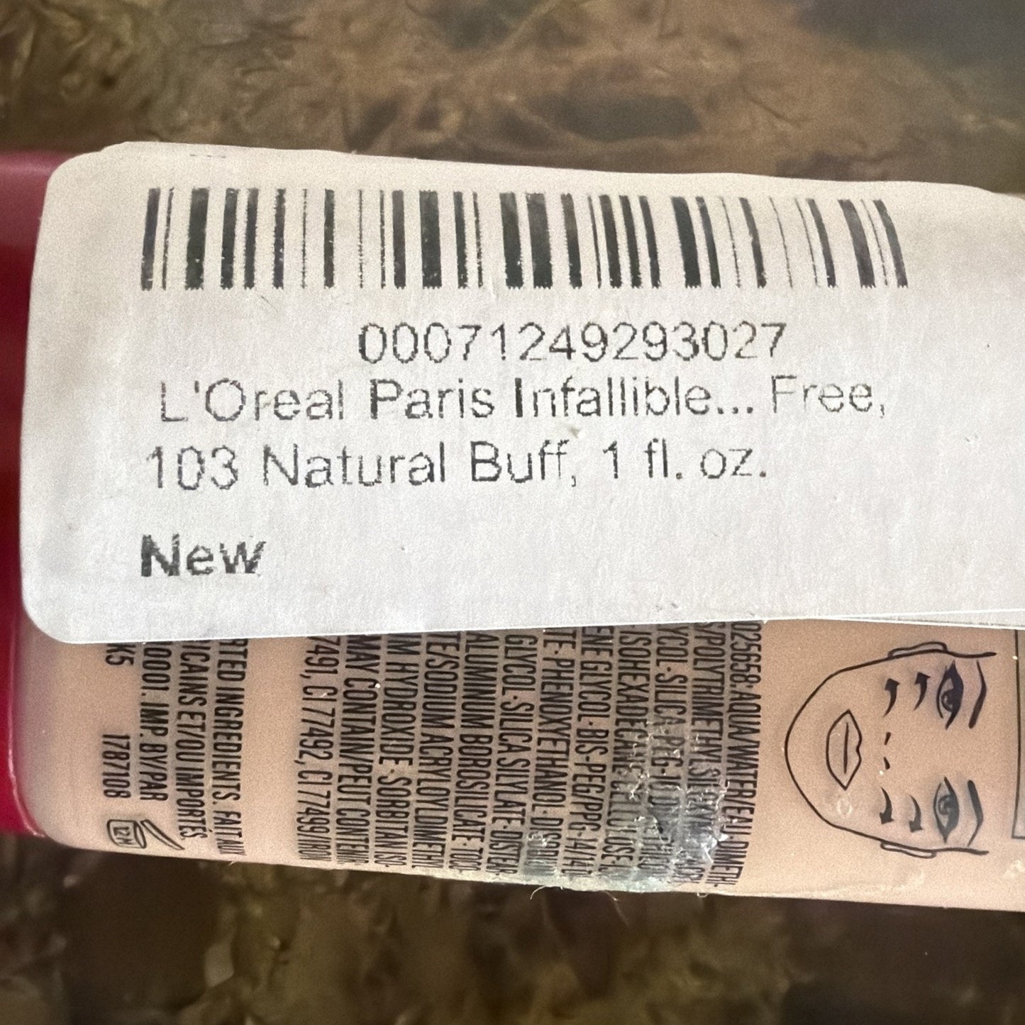 Close-up view of a beige liquid foundation bottle with a white label showing a barcode, product name "L'Oreal Paris Infallible," shade number 103 Natural Buff, volume 1 fl. oz., and a simple face illustration on the packaging.