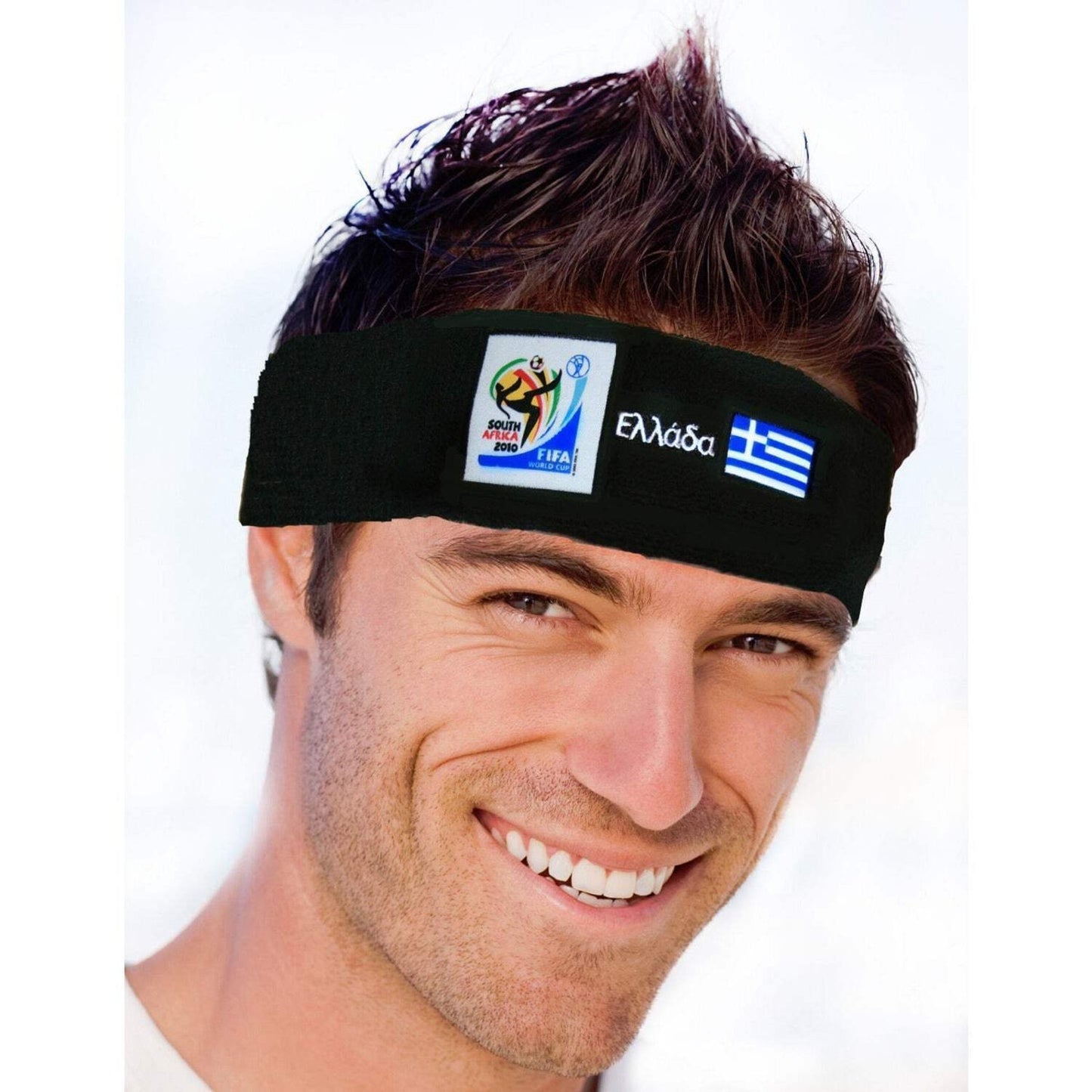 Man smiling and wearing a black headband featuring the 2010 FIFA World Cup South Africa logo, Greek text, and the blue and white flag of Greece on a white background.