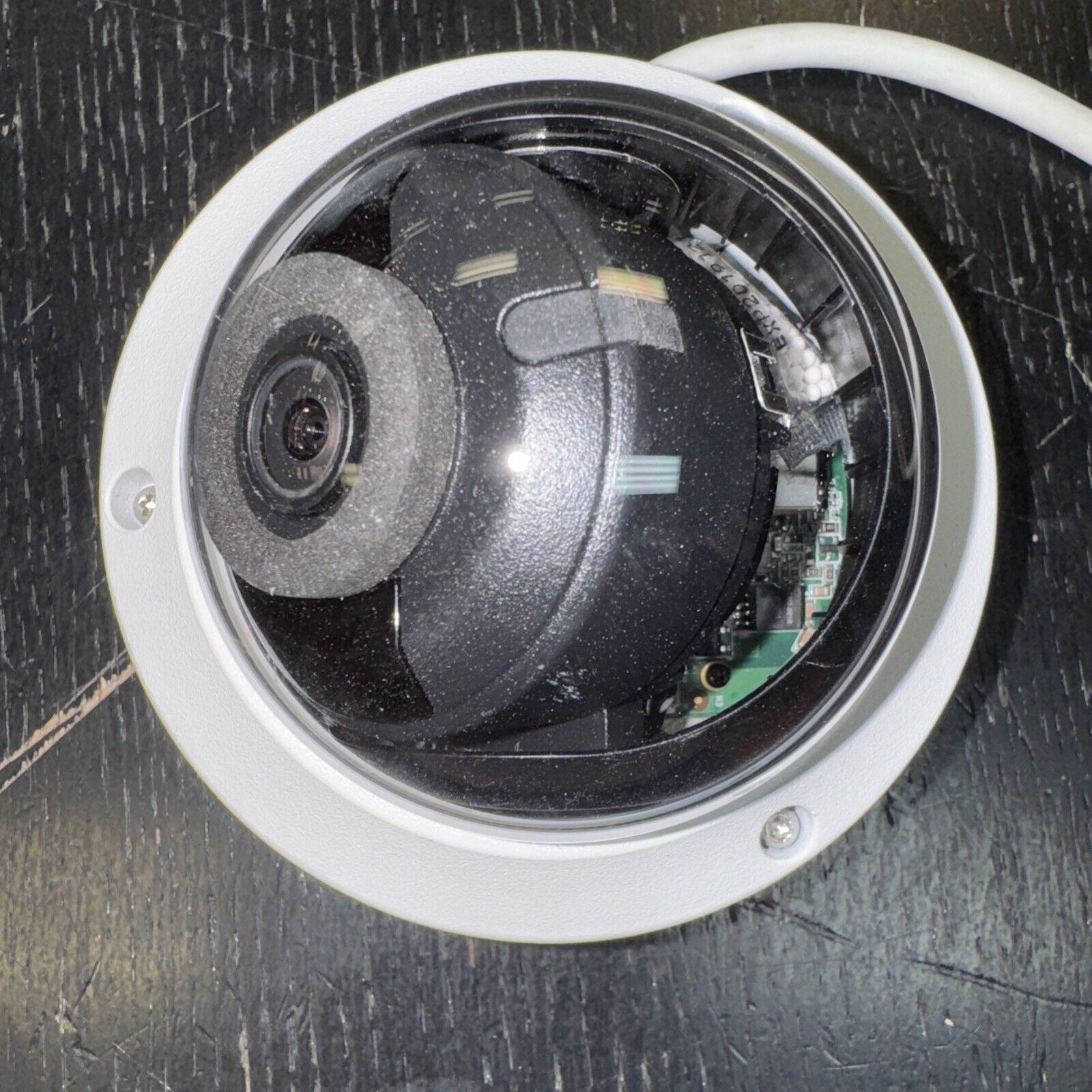 Hikvision DS-2CD1143G0-IS dome network camera with 4MP resolution and visible internal components on black surface
