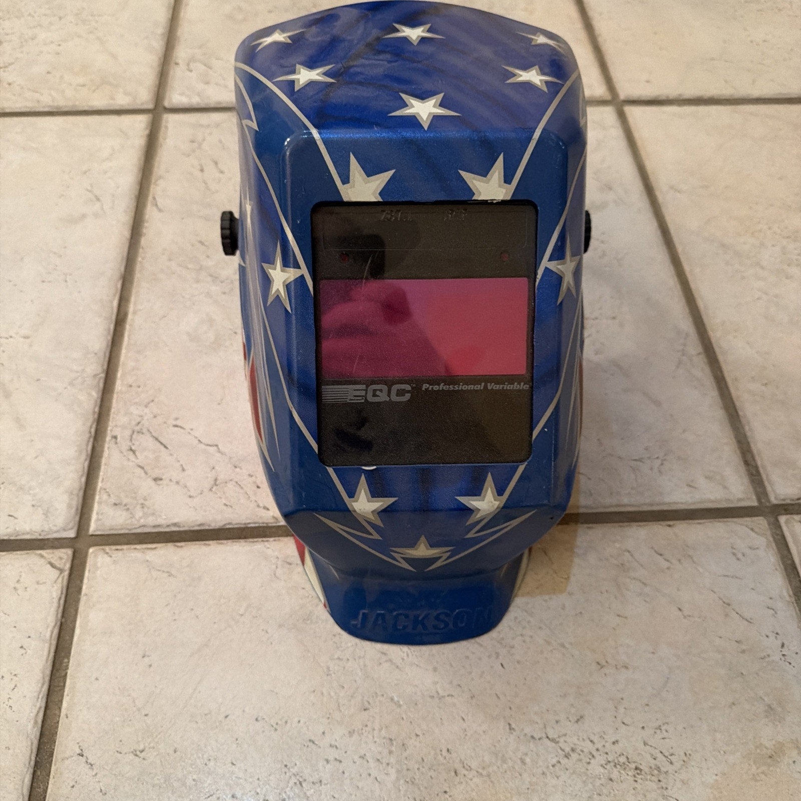 Jackson Safety HSL100 Glory Welding Helmet PRO-V auto darkening with blue and white star design on tiled floor