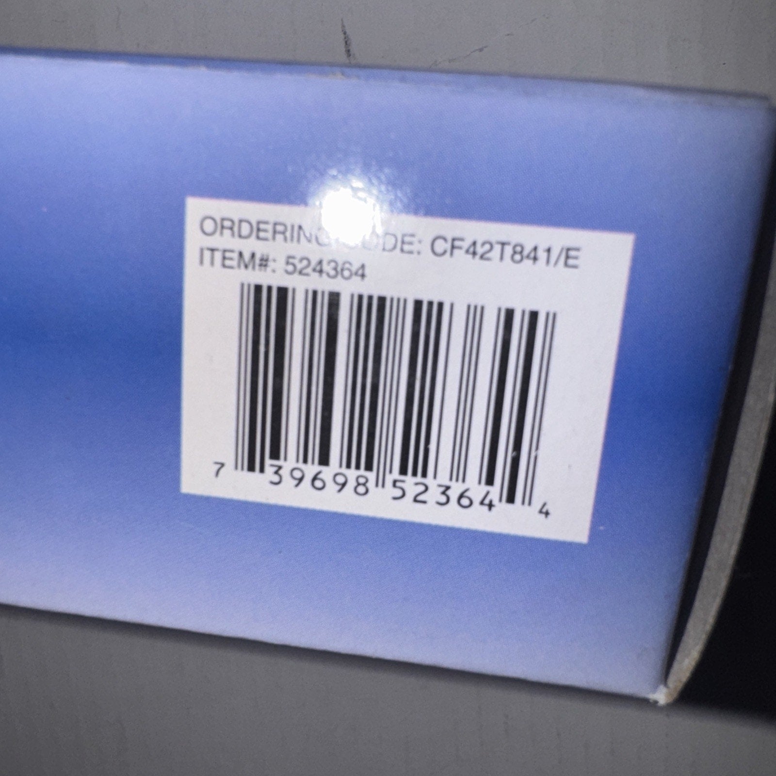 Close-up of bulb packaging showing barcode and ordering code CF42T841/E with item number 524364 on blue box corner