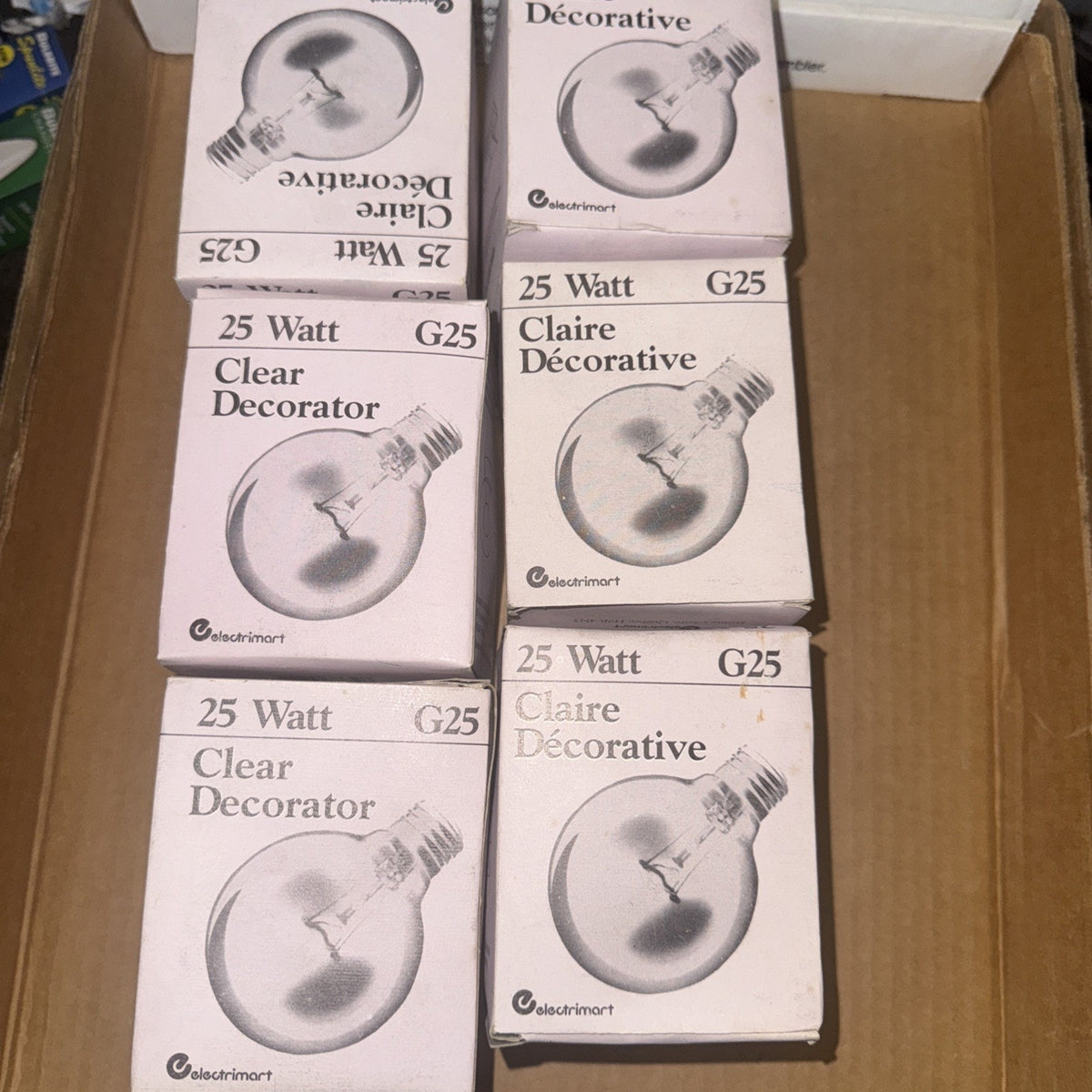 Six Electrimart clear G25 globe light bulb boxes, 25 watt decorative bulbs with E26 base shown in cardboard box