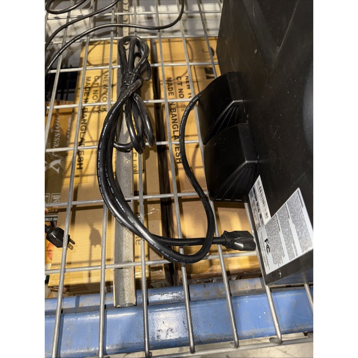 Close-up of Tripp Lite SU1500RTXL2UA Smart Online UPS power cable and black battery unit on metal rack shelf