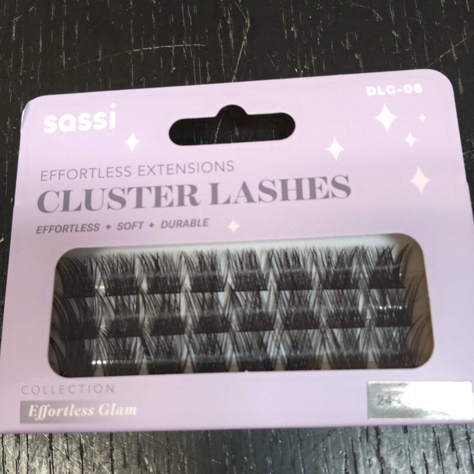 Light purple packaging of sassi brand cluster eyelash extensions labeled as effortless, soft, and durable, showing multiple rows of black lashes inside a transparent window.