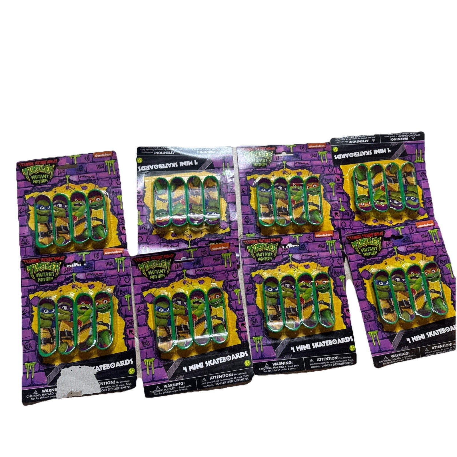 Teenage Mutant Ninja Turtles party favors set showing mini skateboard toys in packaging with purple brick wall design