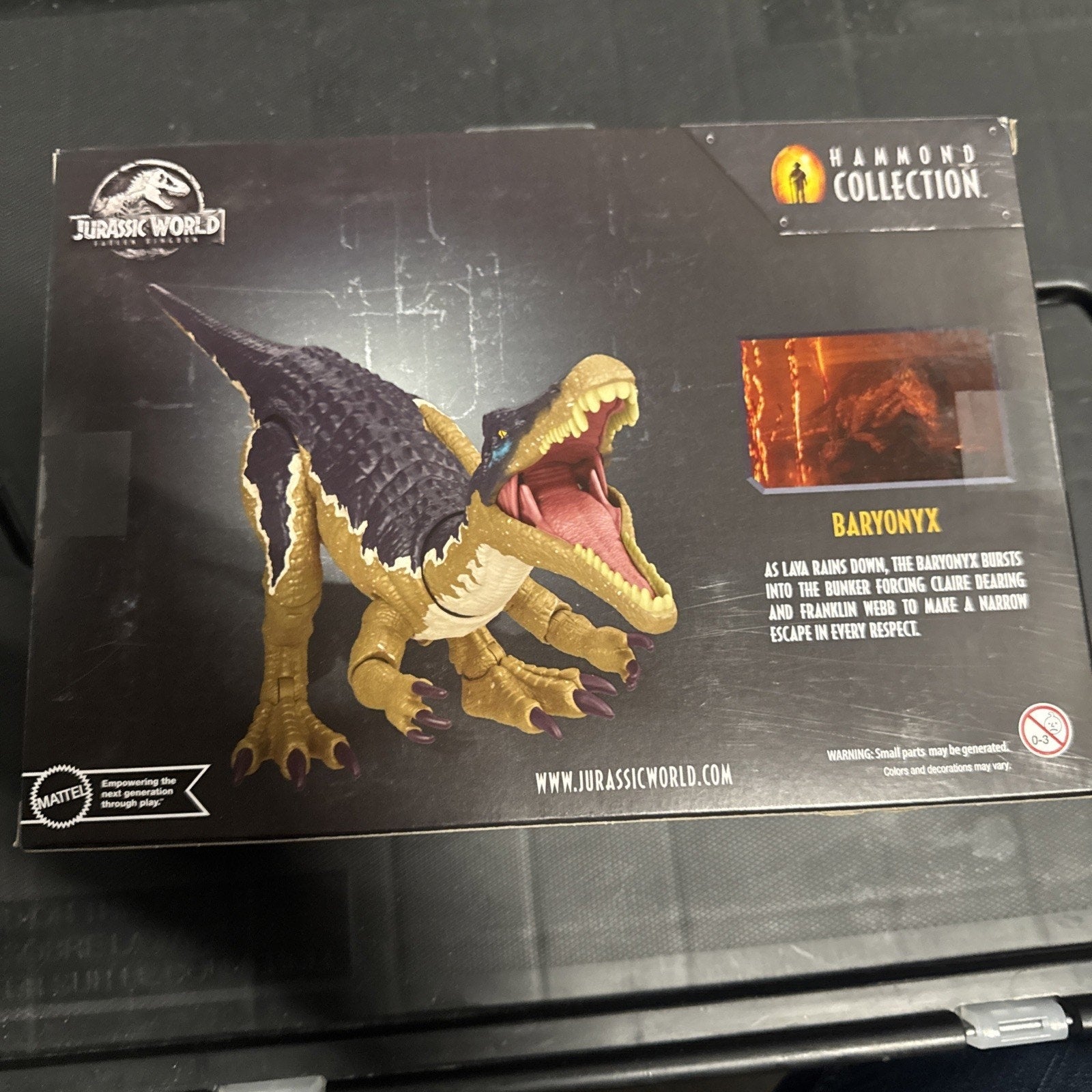 Jurassic World Baryonyx 12-inch action figure from Hammond Collection in unopened packaging with black background