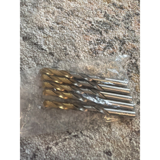 Set of four metal twist drill bits with spiral flutes, packaged together in a clear plastic bag, placed on a textured carpeted surface.