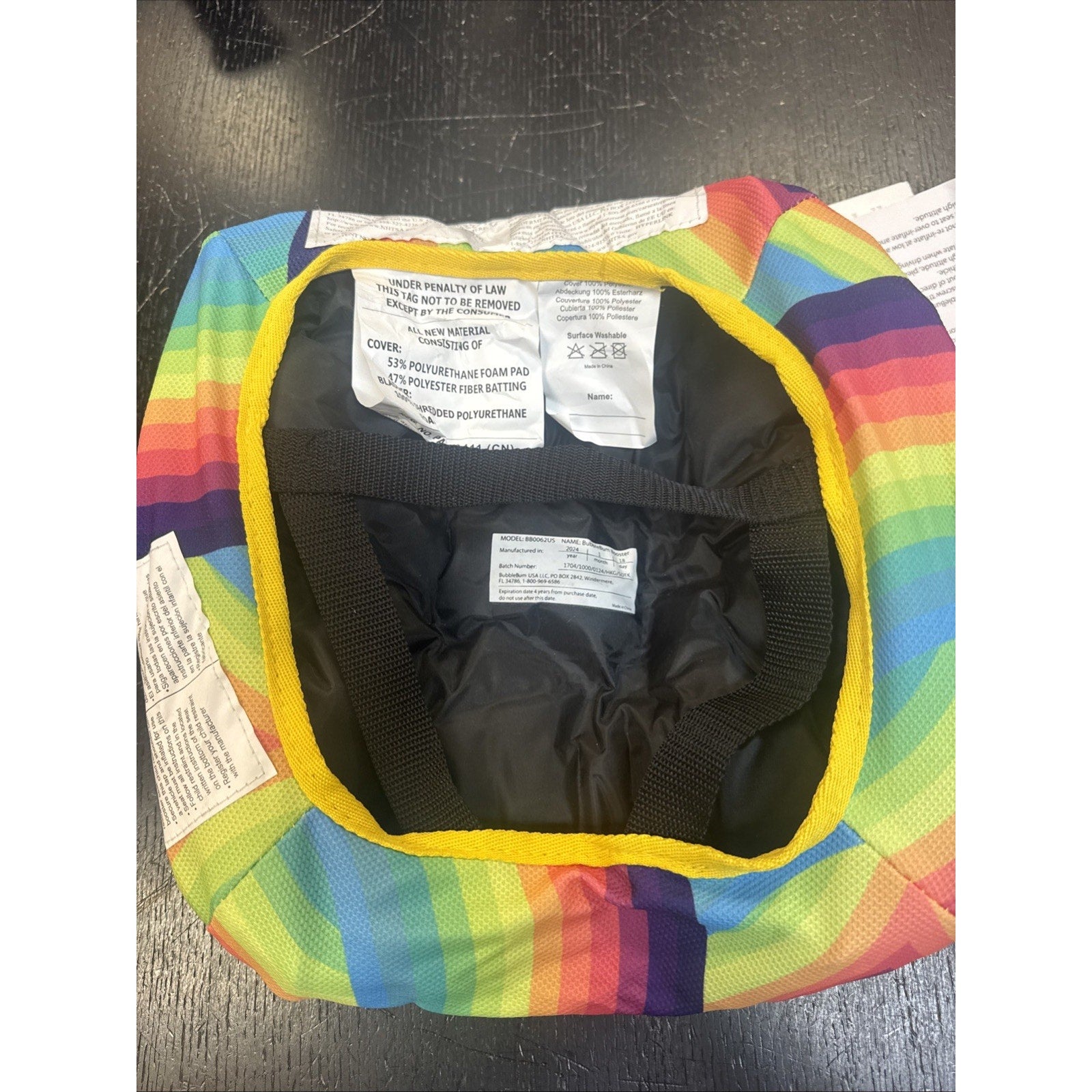 Bubble Bum inflatable backless booster car seat with rainbow cover and black straps for kids ages 4-10