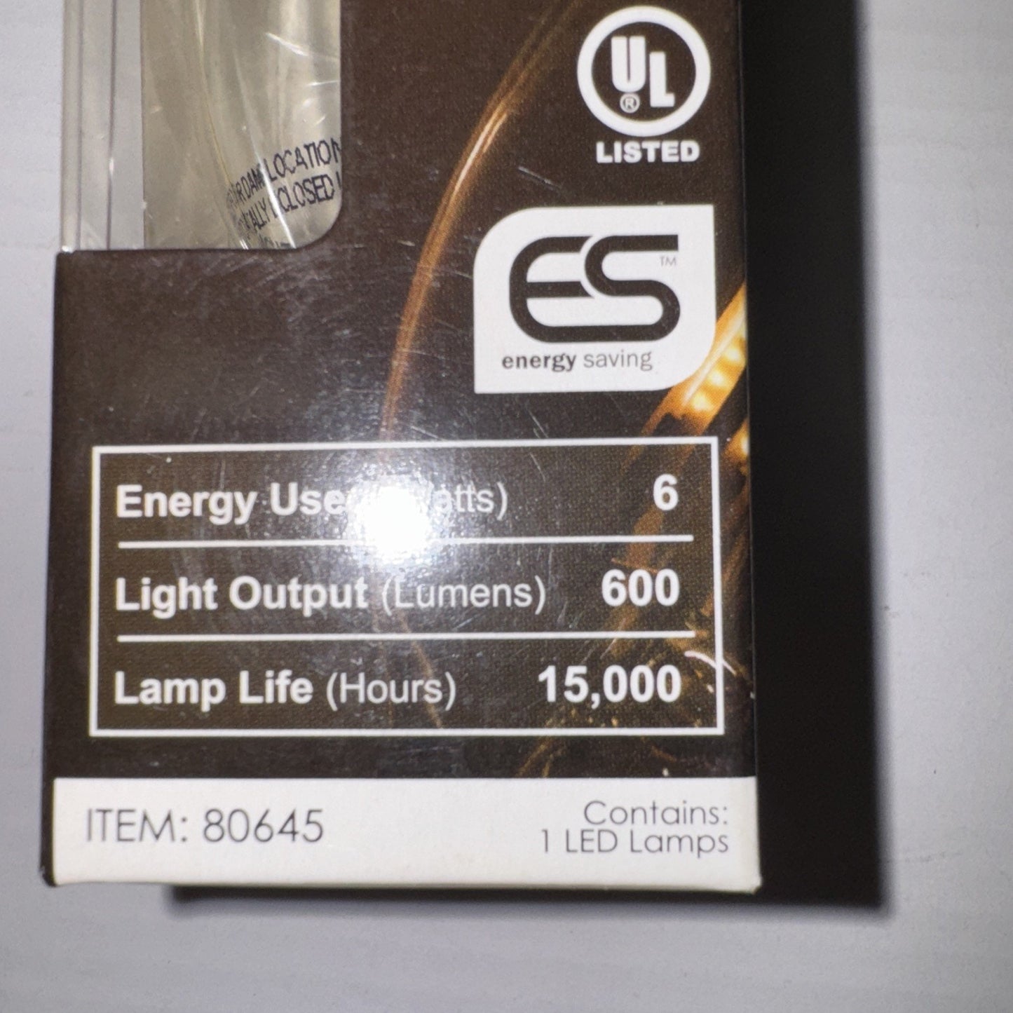 Close-up of Sunlite Chandelier LED bulb packaging showing 6 watt, 600 lumens, and 15,000 hours lamp life details
