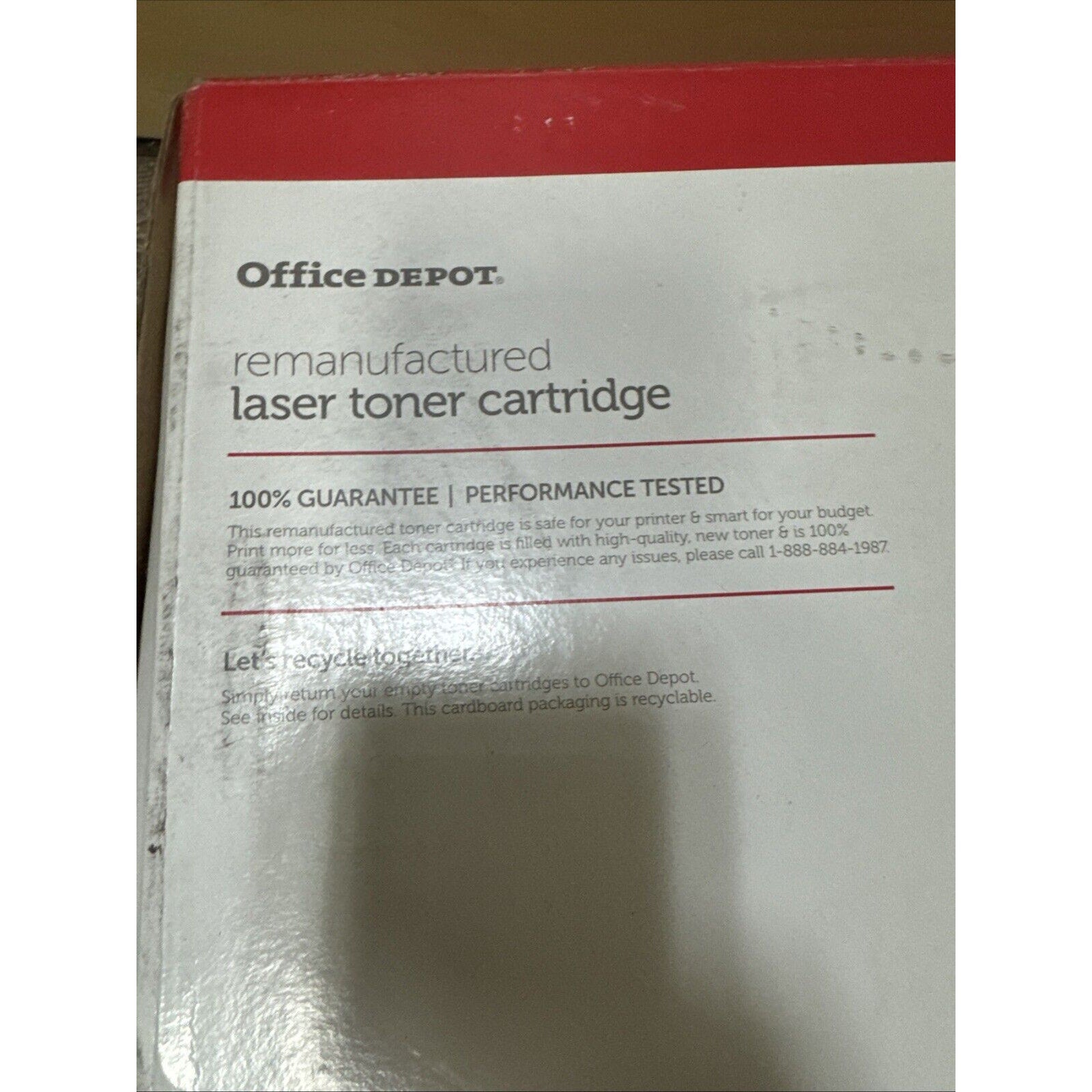 Close-up of an Office Depot remanufactured laser toner cartridge box with text highlighting 100% guarantee, performance tested, and recycling information on a white and red label.