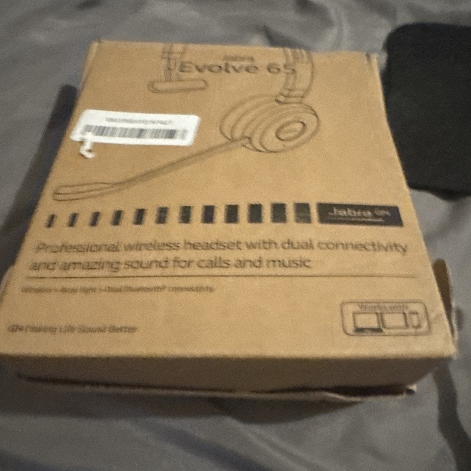 Jabra Evolve 65 professional wireless headset box showing dual connectivity and Bluetooth features for calls and music