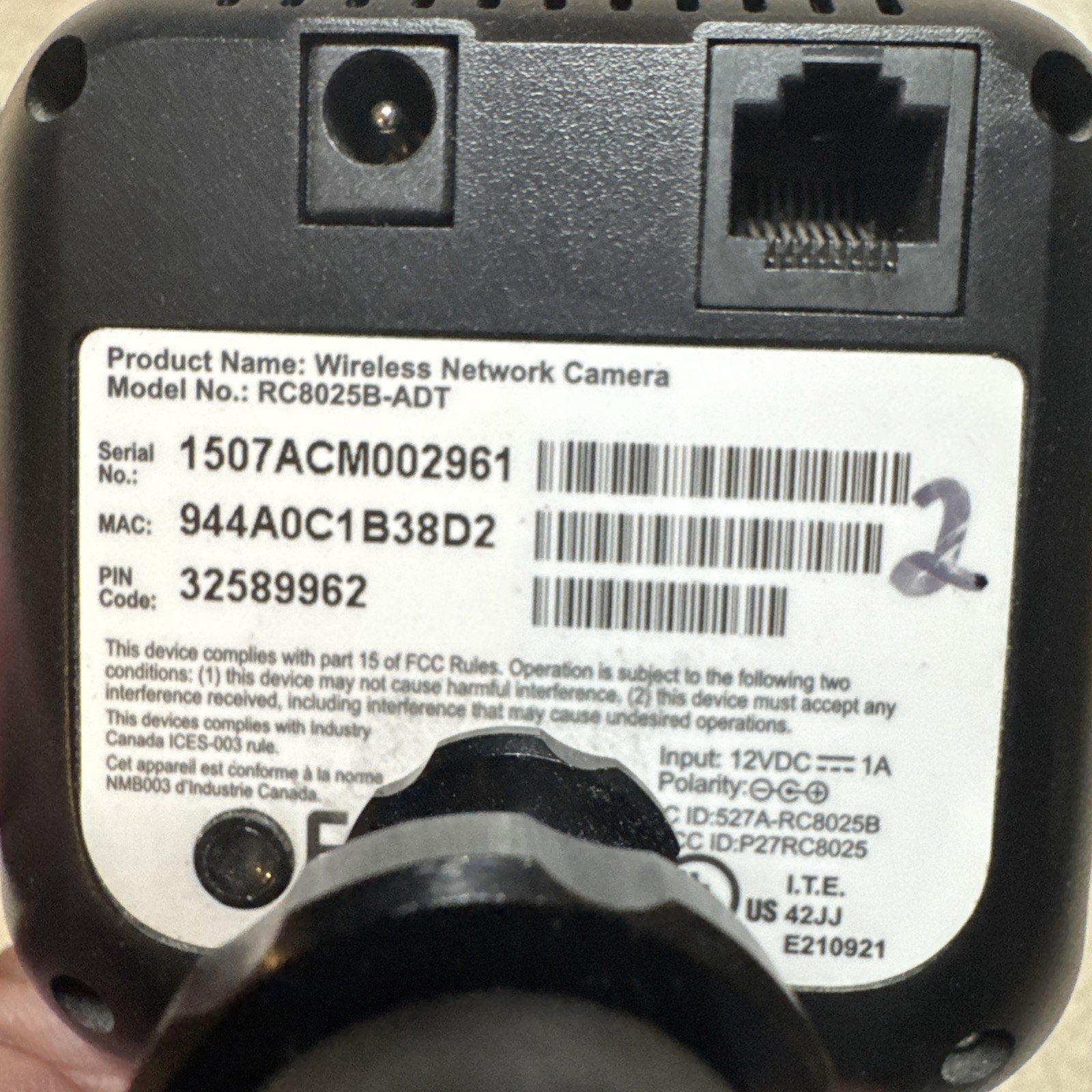 Back view of ADT Wireless Network Camera Model RC8025B-ADT showing serial number, MAC, and power input details