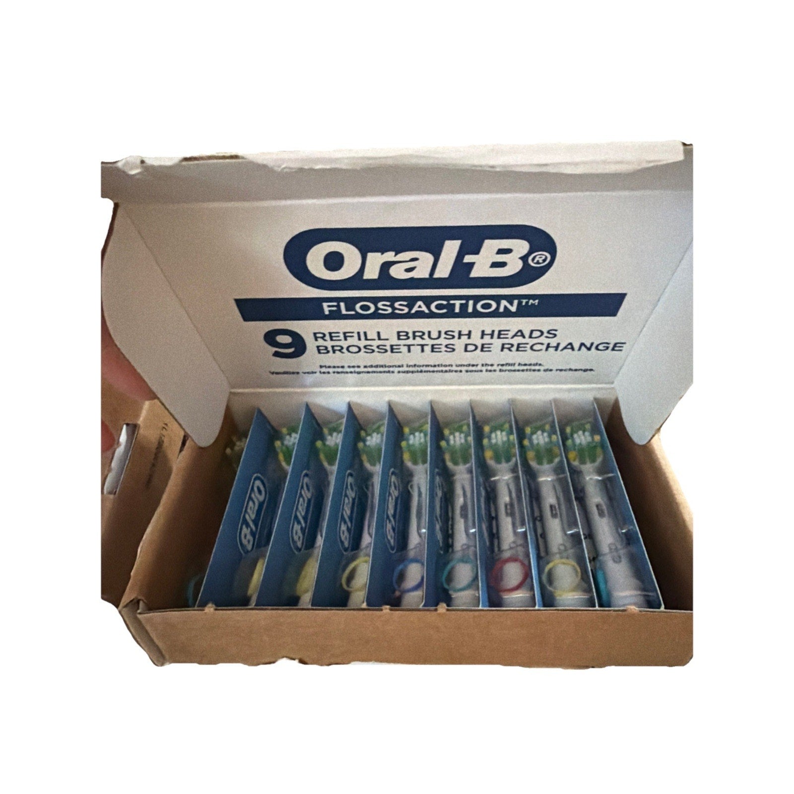 Oral-B FlossAction 9-count electric toothbrush replacement brush heads in open box showing individual sealed packs