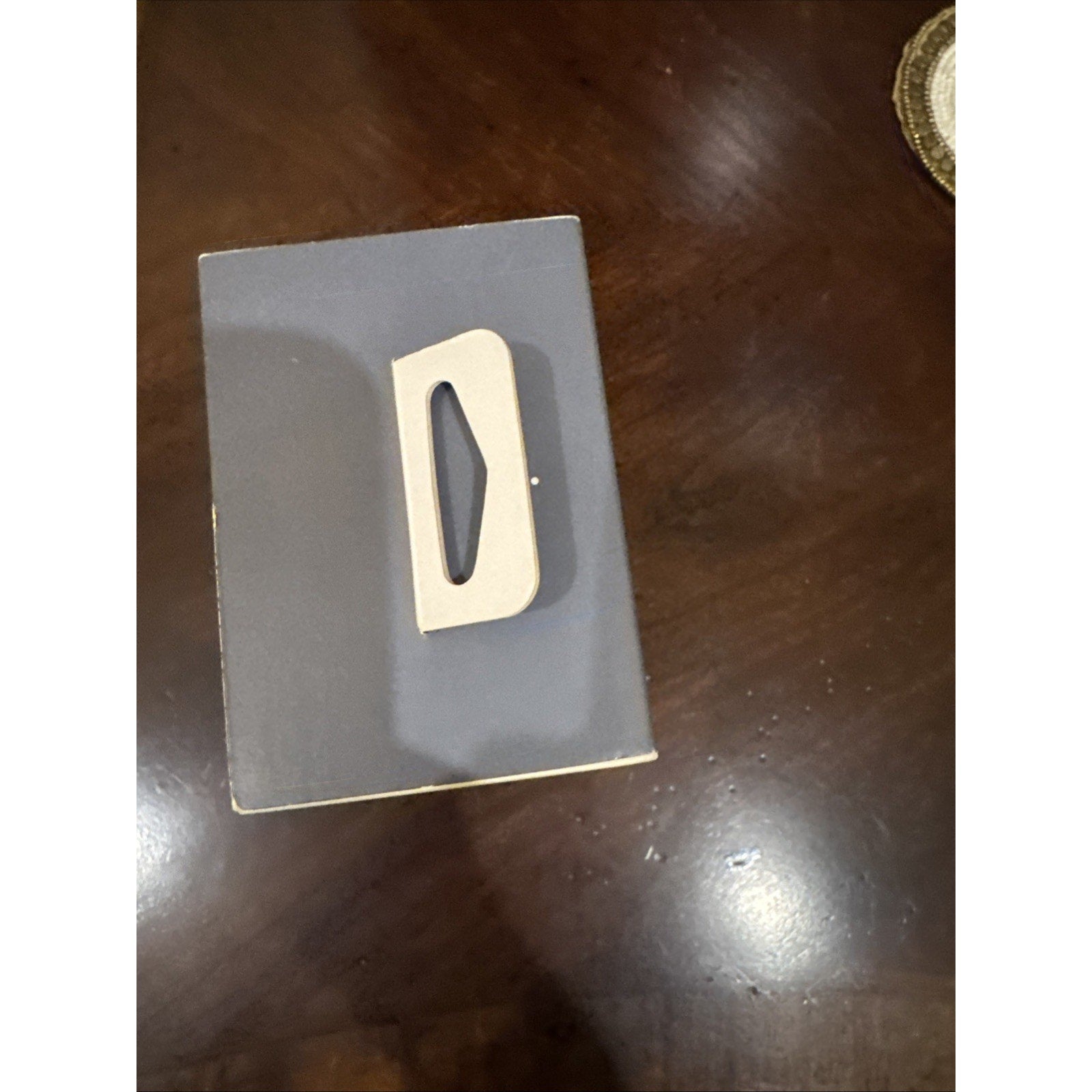 Box for Fitbit Versa 4 Fitness Smartwatch in Waterfall Blue band with platinum aluminum case on wooden surface