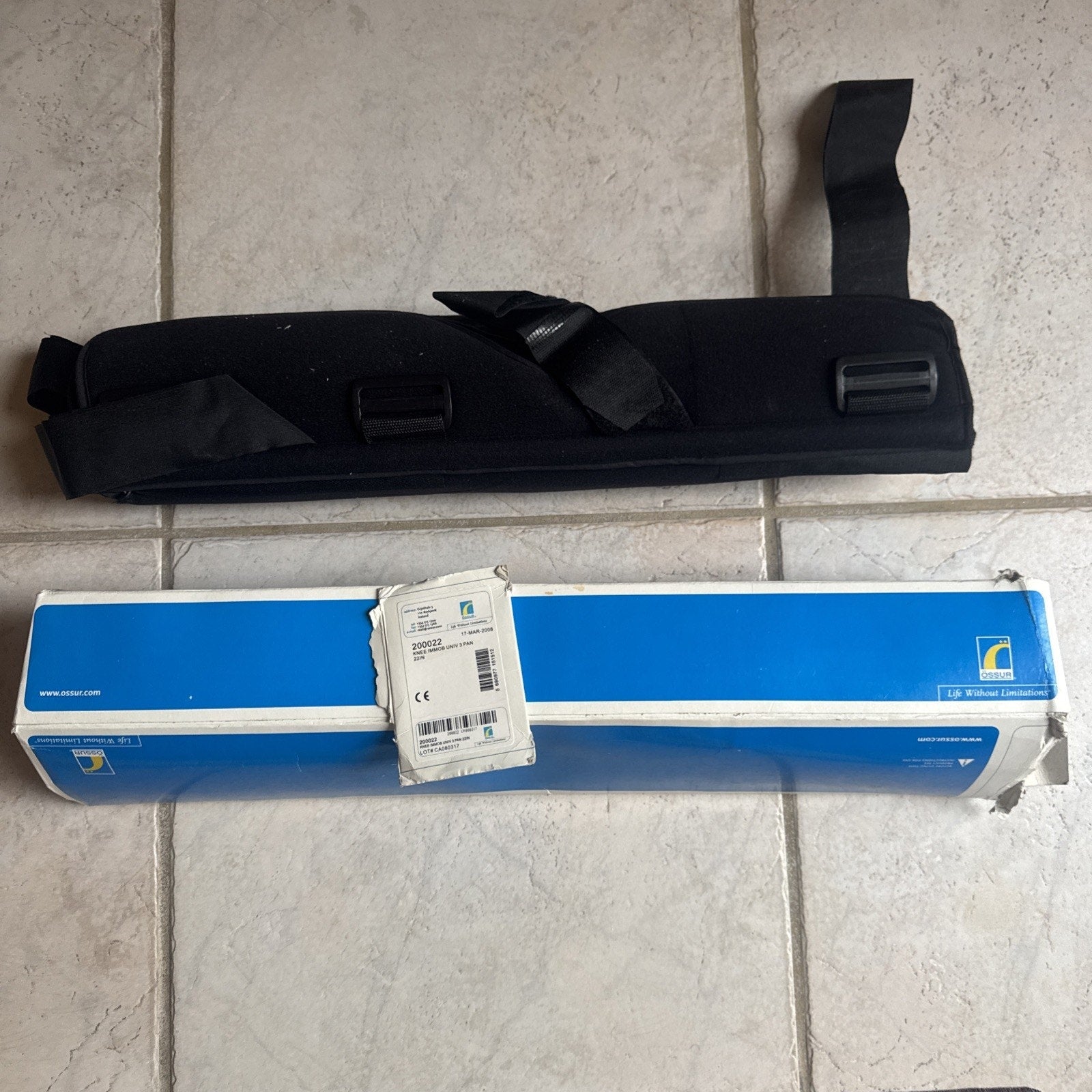 Össur Knee Immobilizer Universal 3-Panel 22” model 200022 with black straps and original blue packaging box visible