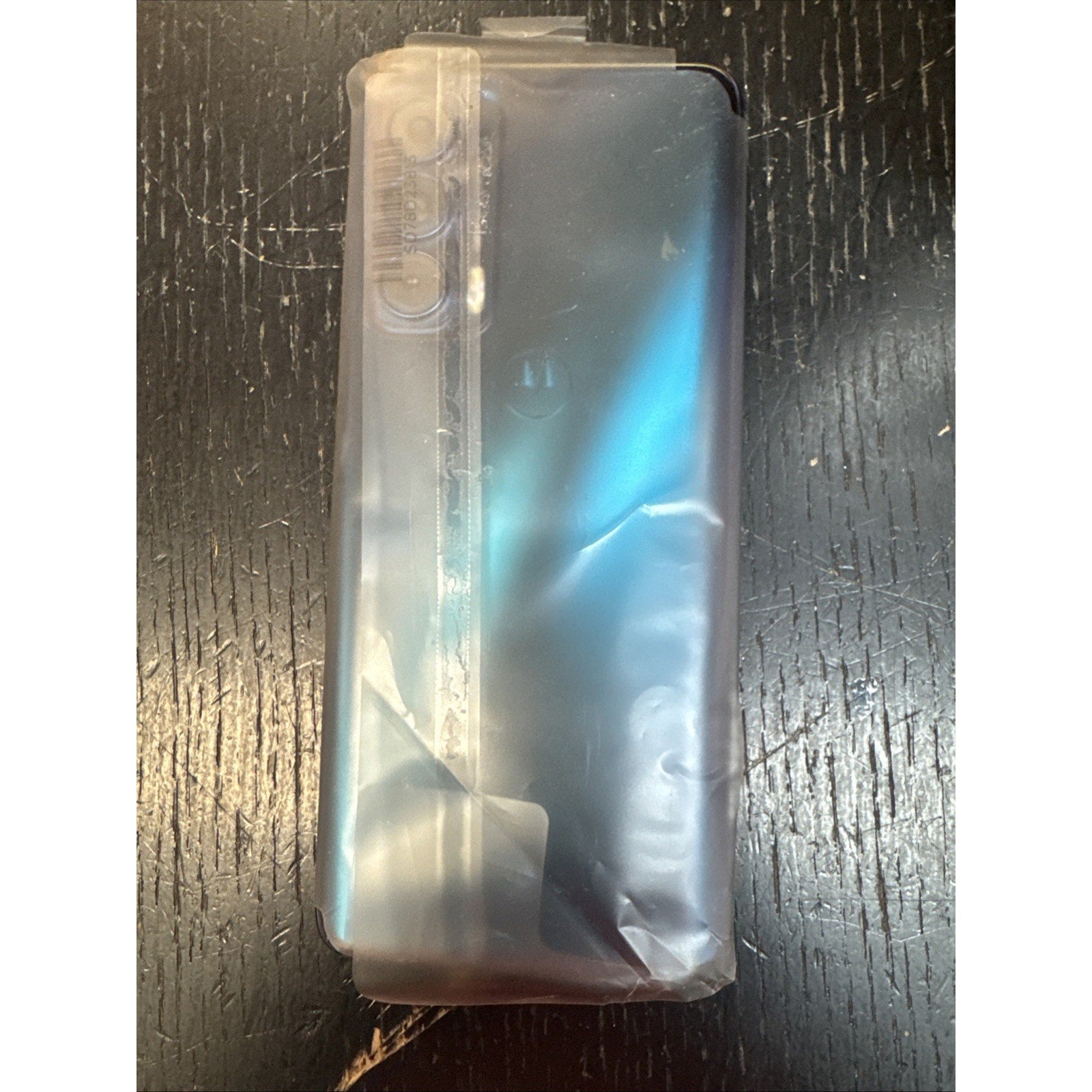 Open Box Motorola Moto Edge Plus 2022 Cosmos Blue 128GB smartphone partially wrapped in protective plastic on dark surface