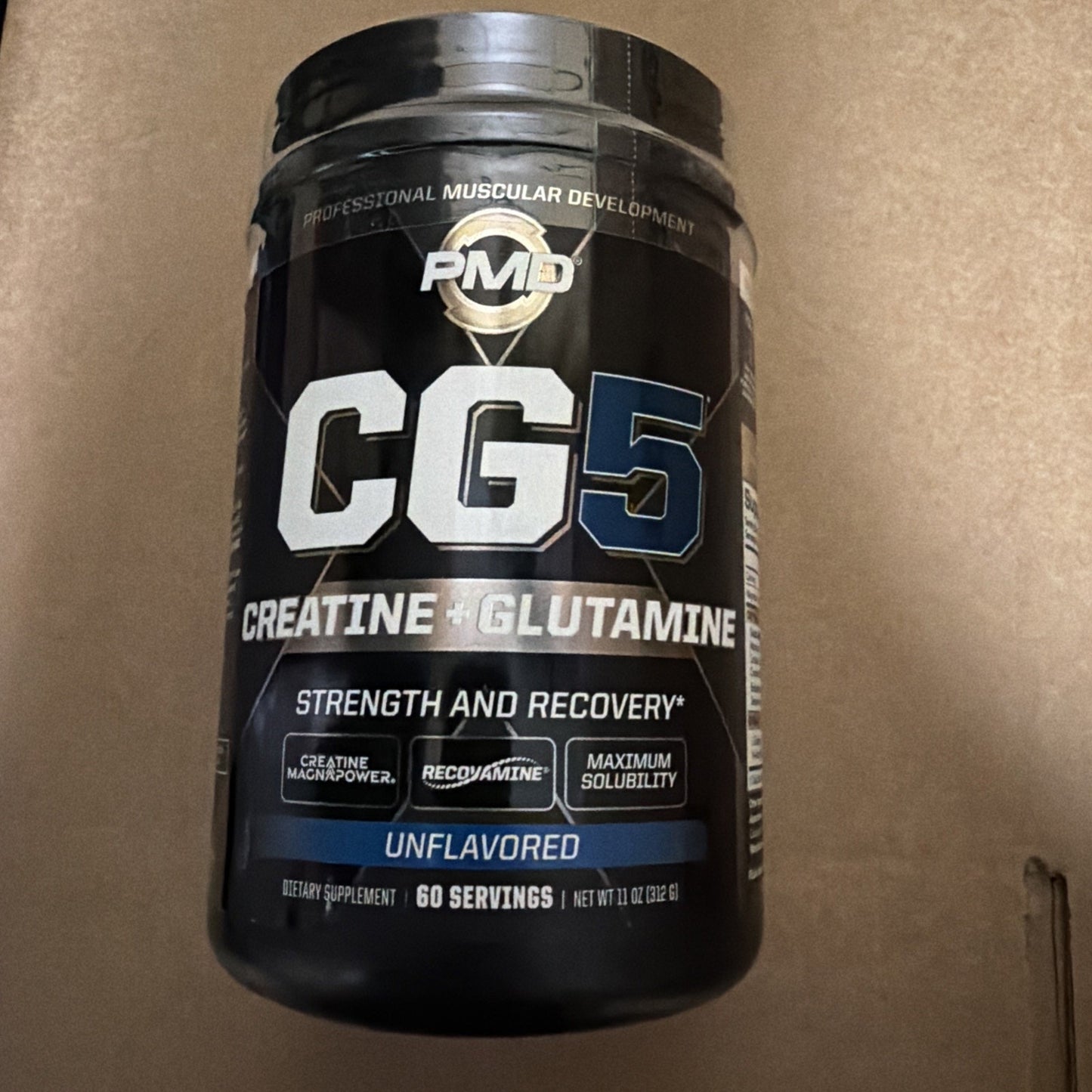 Black container of PMD CG5 dietary supplement featuring creatine and glutamine for strength and recovery, highlighting creatine magnipower, maximum solubility, and 60 servings unflavored.