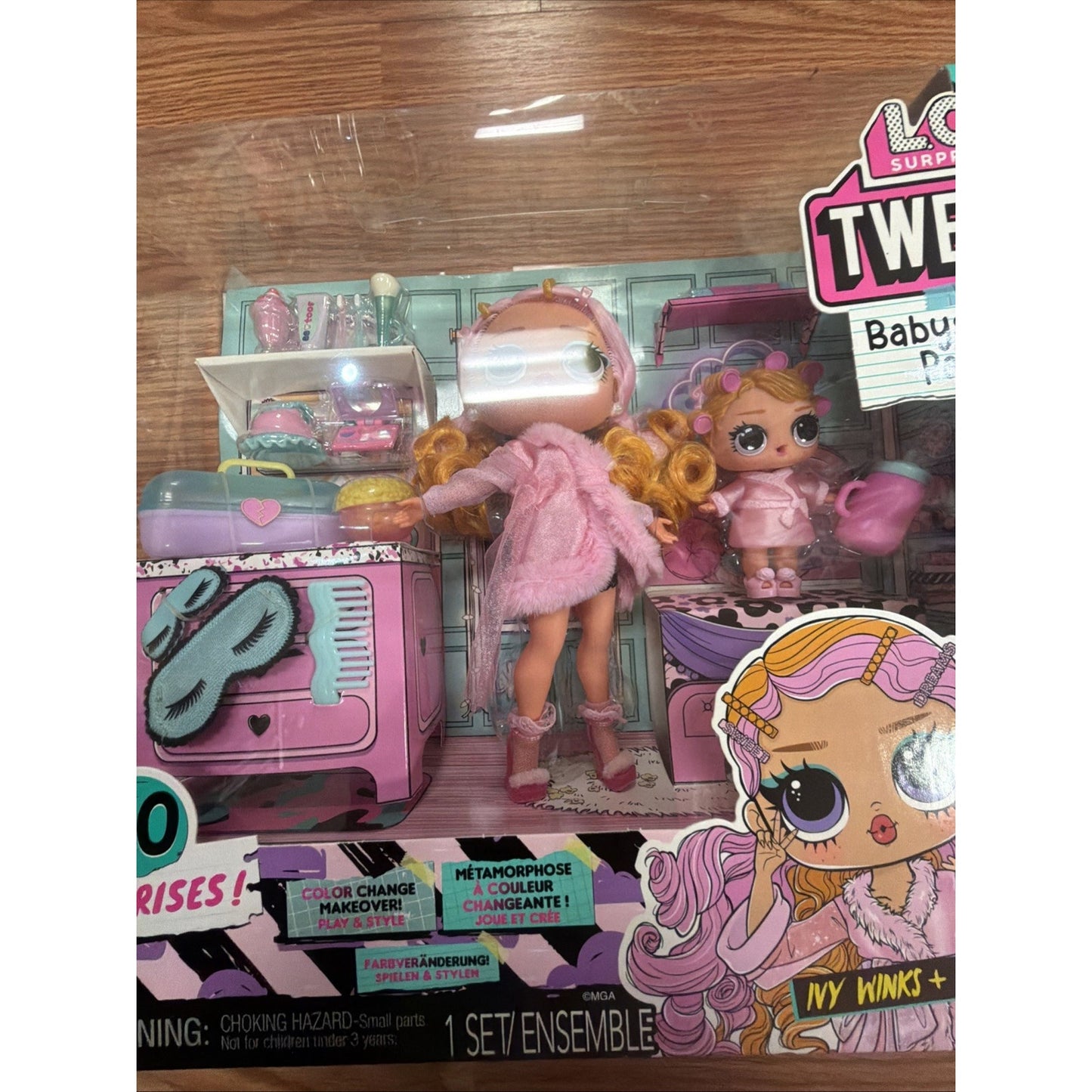 Set of LOL Surprise Tweens dolls dressed in pink bathrobes with accessories including a kitchen playset, displayed in clear plastic packaging on a wooden surface.