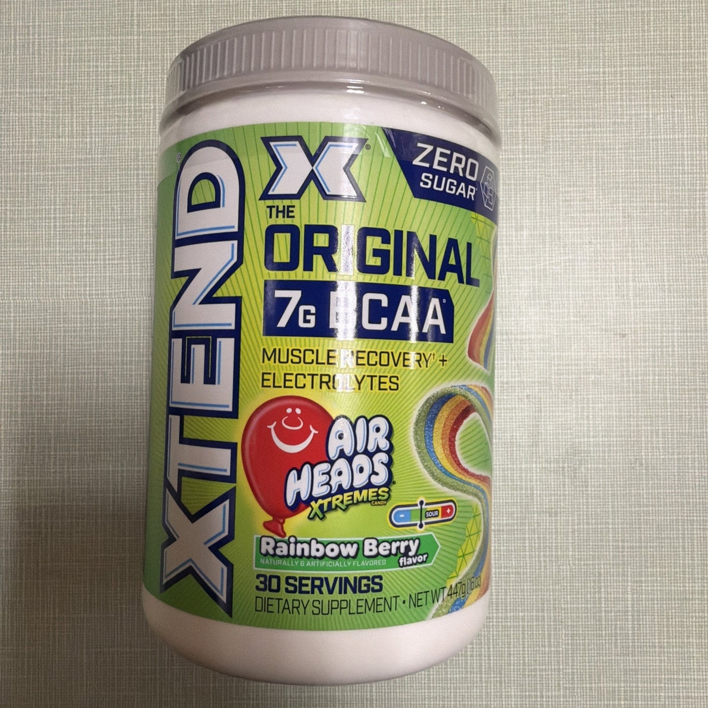 Container of Xtend Original dietary supplement featuring 7g BCAA, muscle recovery, electrolytes, zero sugar, and Air Heads Xtremes Rainbow Berry flavor with 30 servings.