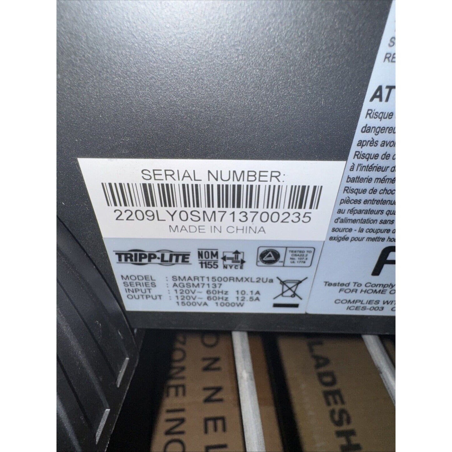 Close-up of Tripp Lite SU1500RTXL2UA UPS label showing model details, serial number, and electrical specifications