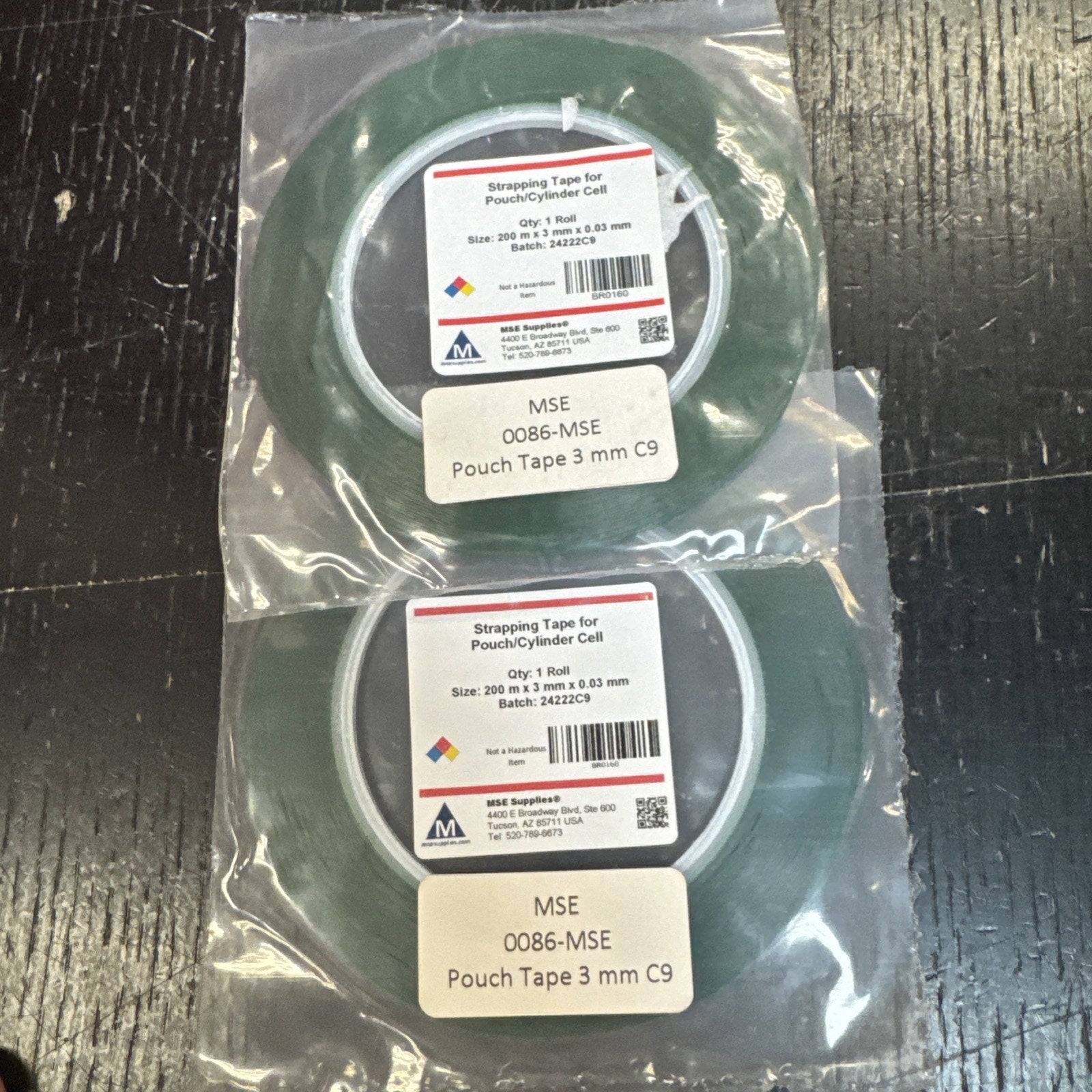 Two rolls of green lithium battery pouch strapping tape sealed in plastic packaging with product labels visible