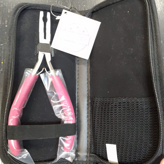 Silver pliers with bright pink handles partially wrapped in plastic, secured with a black elastic band inside an open black zippered carrying case with a mesh pocket on the right side.