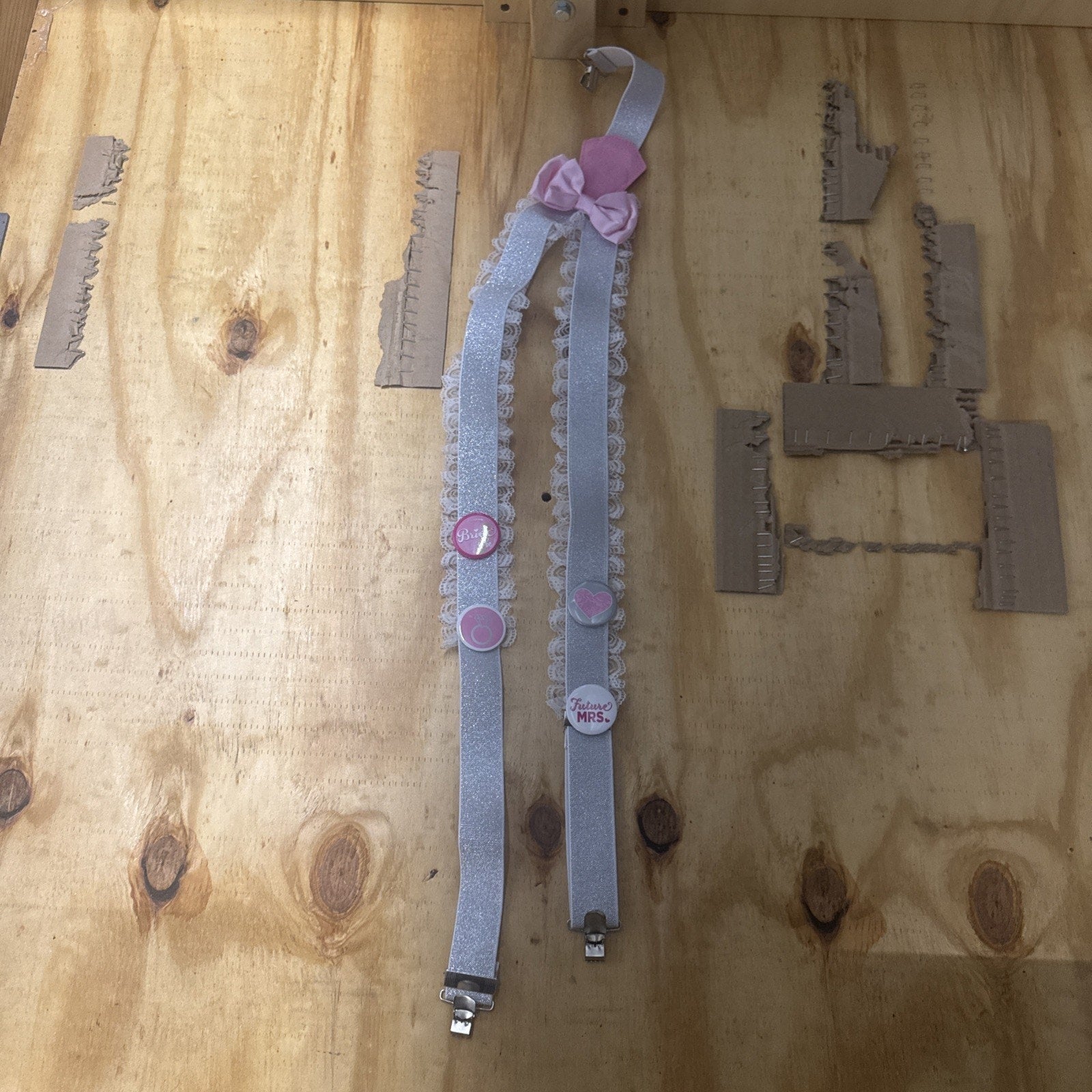 Bride future Mrs. bachelorette party garter suspender with pink bow and decorative pins on lace straps