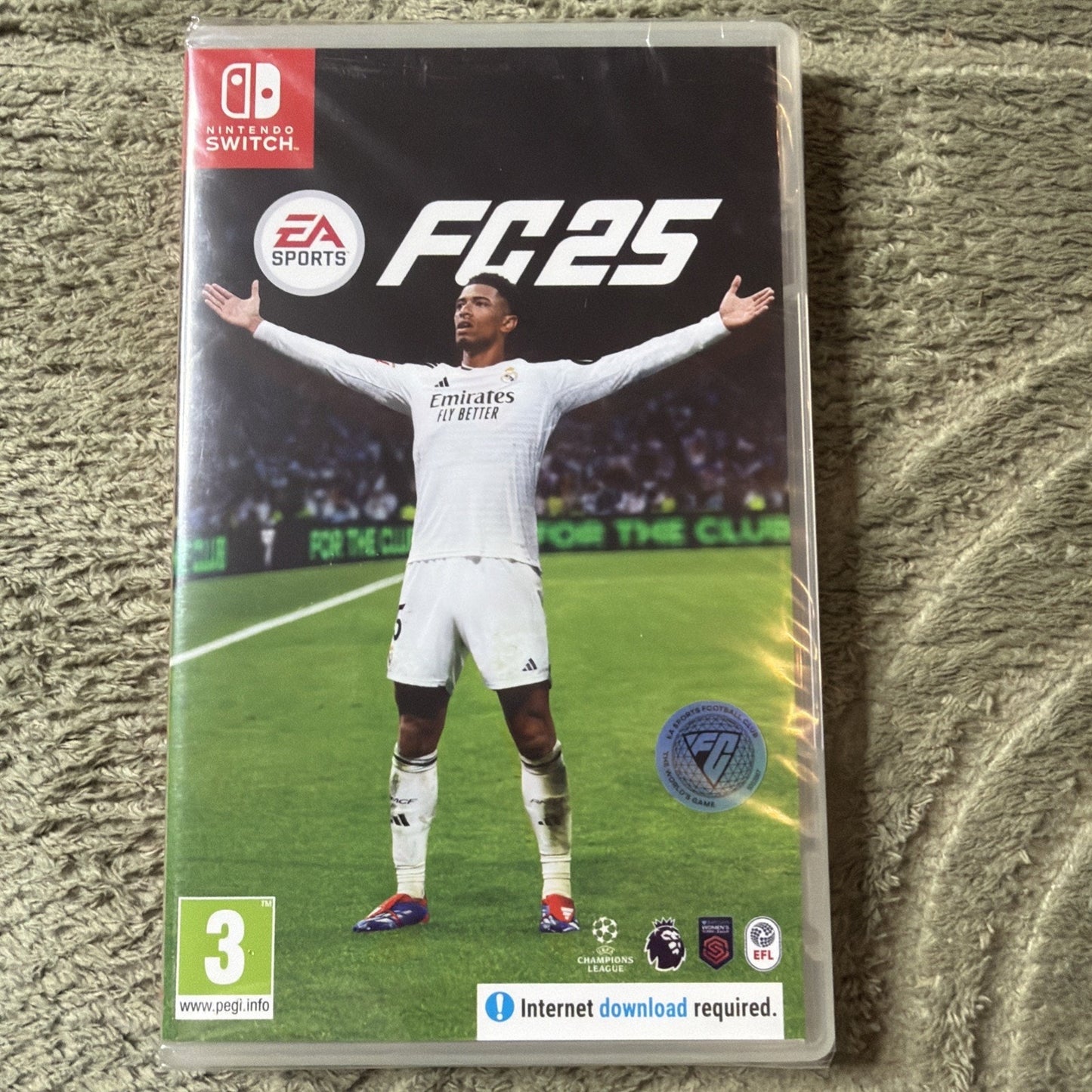 Nintendo Switch game case for EA Sports FC 25 featuring a soccer player in a white jersey with arms outstretched on a stadium field background, with rating and download information.
