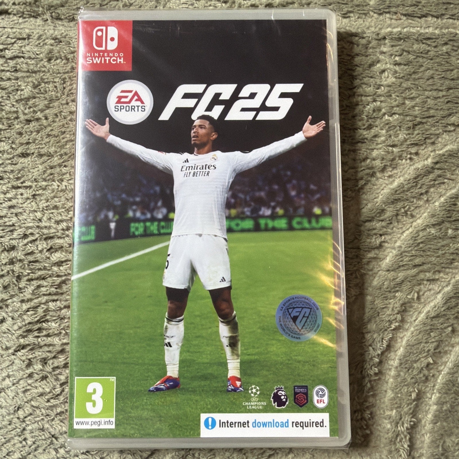 Nintendo Switch game case for EA Sports FC 25 featuring a soccer player in a white jersey with arms outstretched on a stadium field background, with rating and download information.