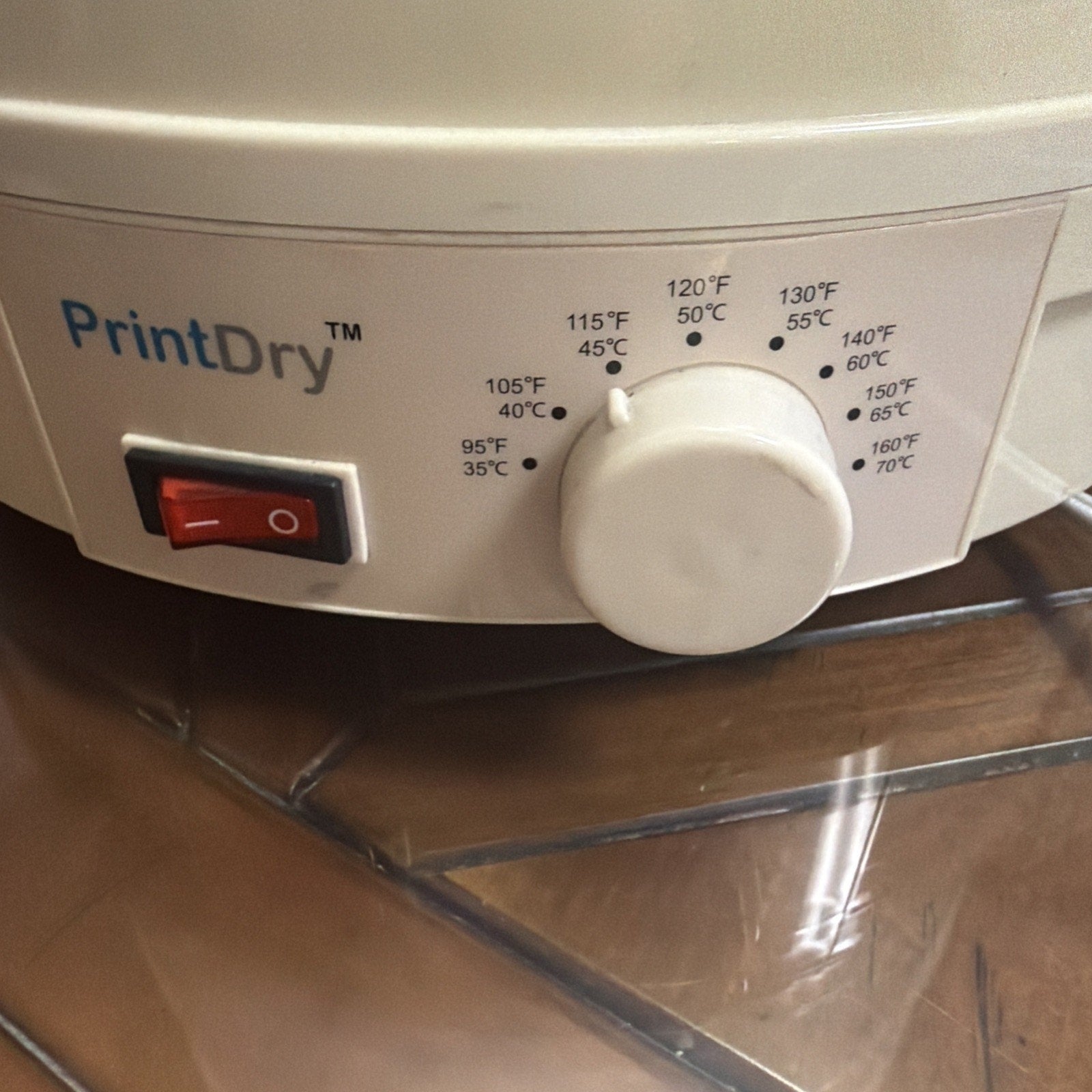 Close-up view of a PrintDry branded device control panel featuring a red power switch and a white temperature dial with temperature settings labeled in both Fahrenheit and Celsius.