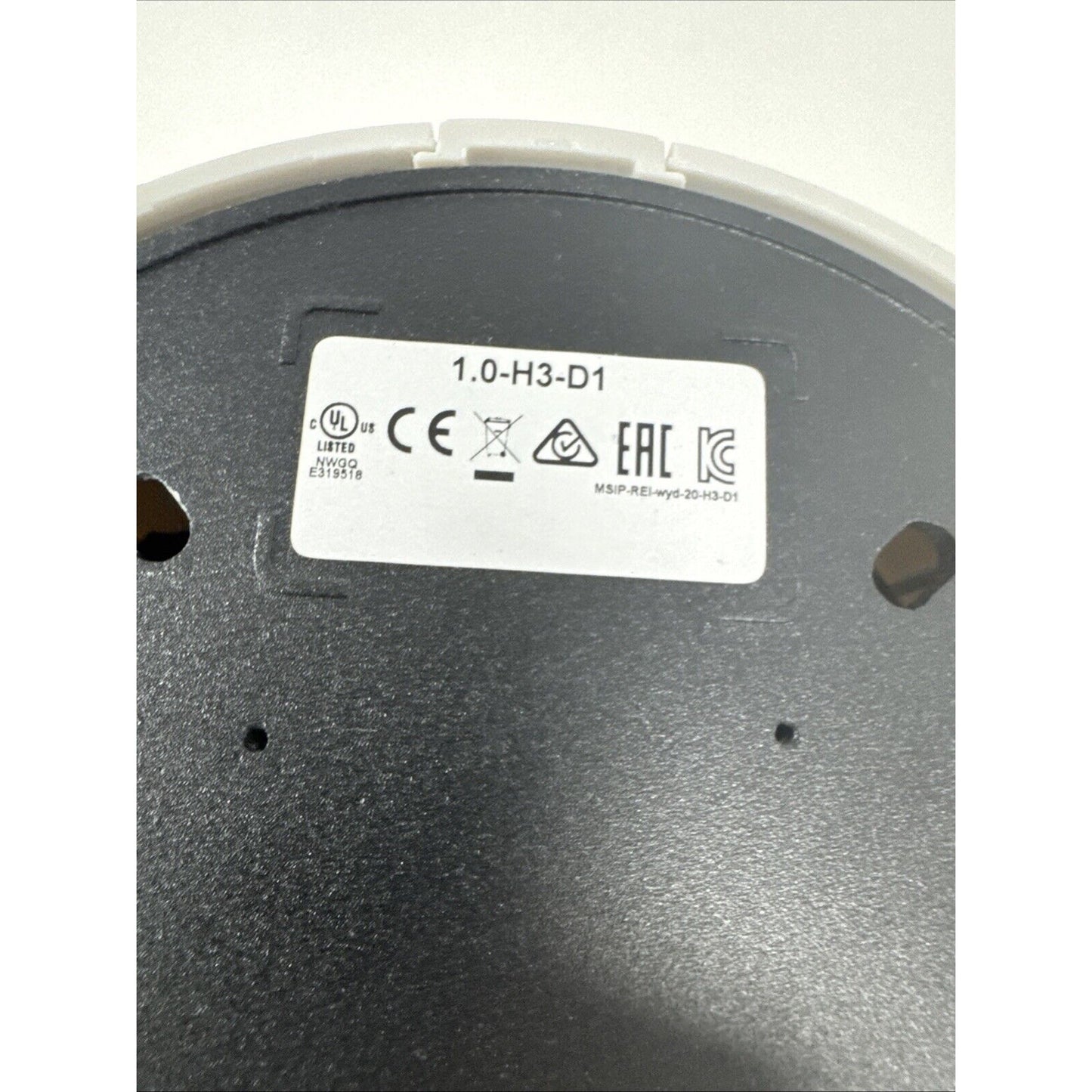 Avigilon 1.0-H3-D1 model label with certification marks on the base of an indoor dome security camera