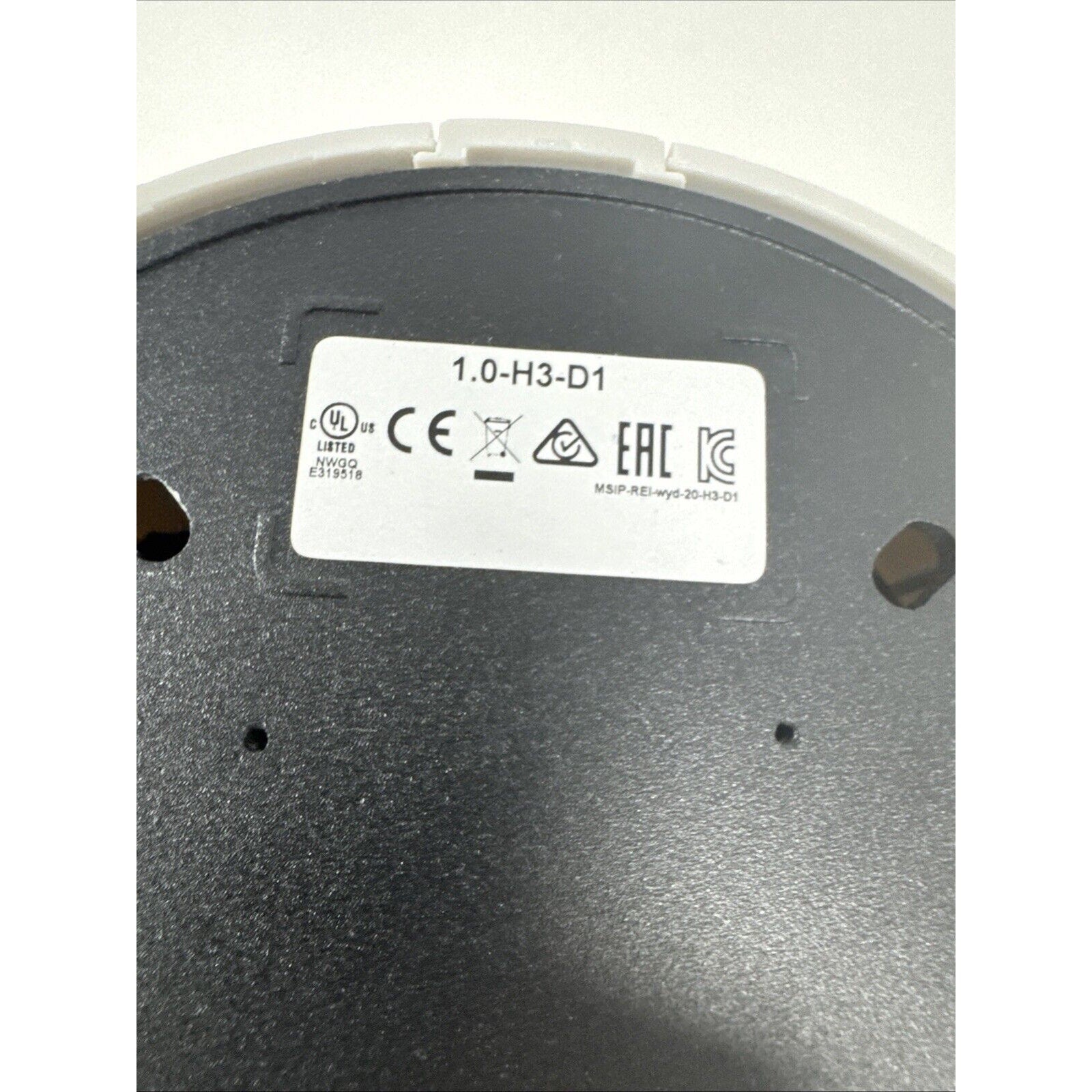 Avigilon 1.0-H3-D1 model label with certification marks on the base of an indoor dome security camera