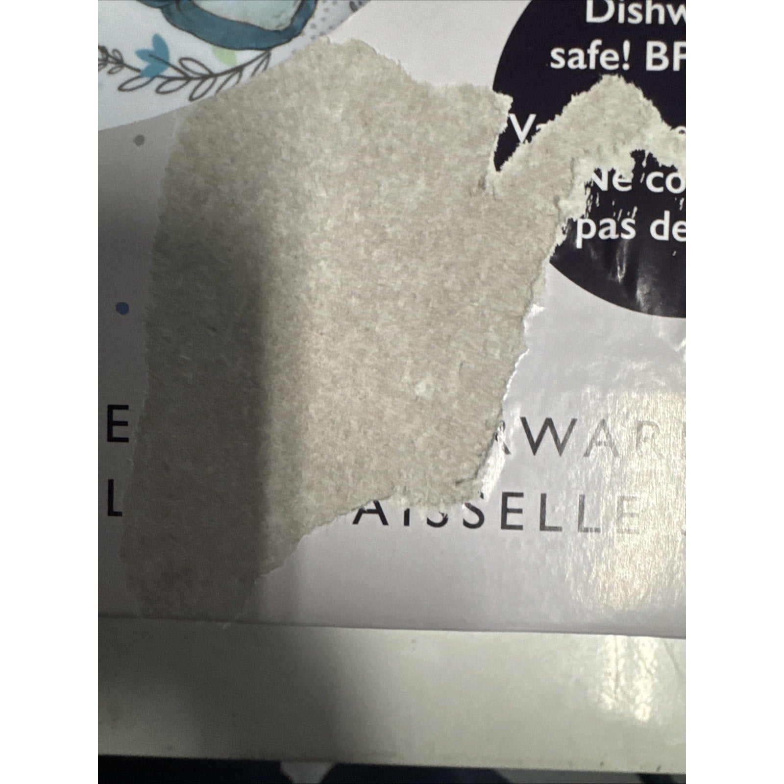 Partially torn label on Beatrix Potter Peter Rabbit 5 Piece Kids Dinnerware Set packaging showing product info background