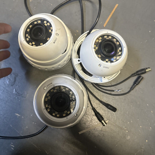 Lot of three white SHIELD analog CCTV dome security cameras with 3.6mm lens and visible cables on gray surface