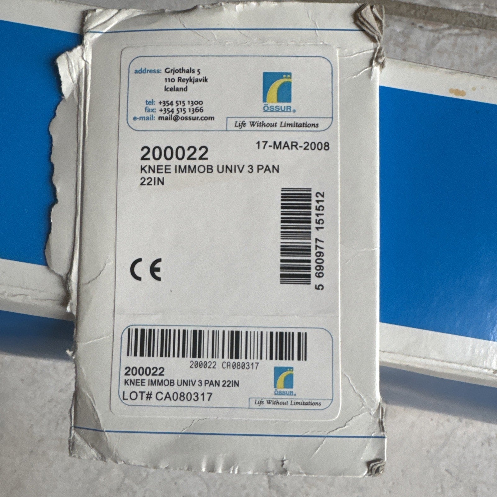 Packaging label for Össur Knee Immobilizer Universal 3-Panel 22-inch model 200022 with contact and lot information