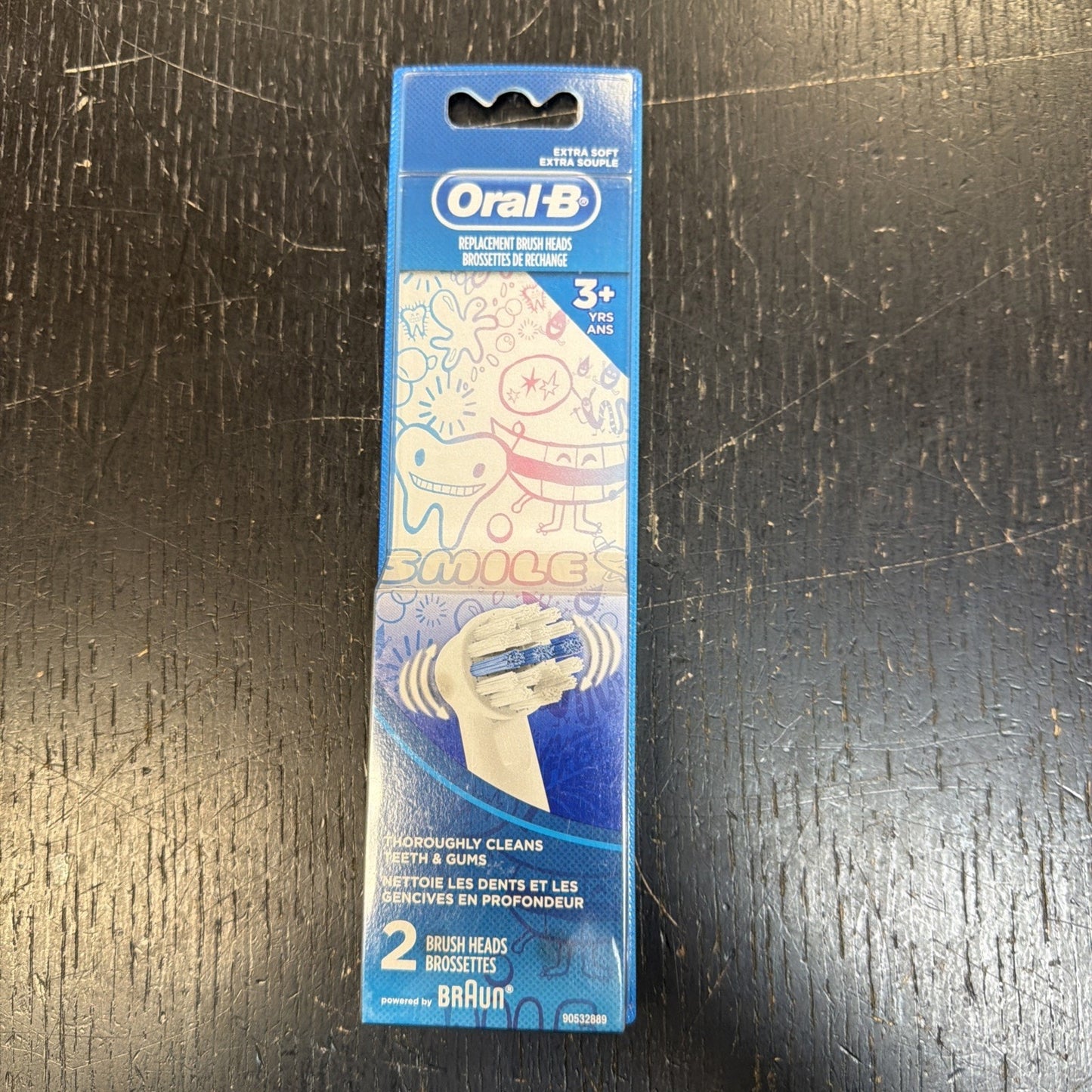 Blue rectangular box of Oral-B replacement brush heads for children aged 3 and up, featuring cartoon dental-themed illustrations and labeled extra soft with two brush heads inside.