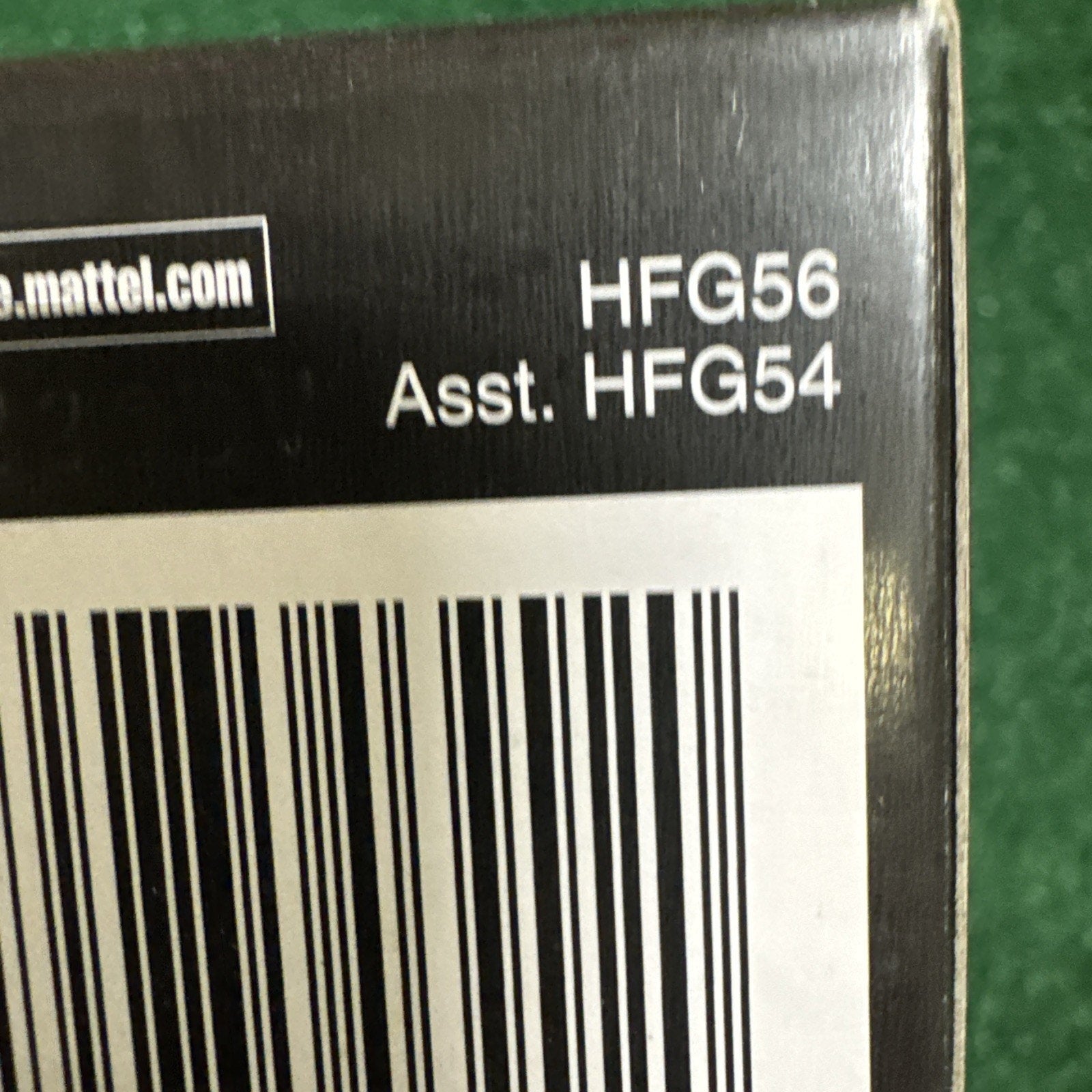 Close-up of Jurassic Park Velociraptor Hammond Collection action figure box showing Mattel product codes HFG56 and HFG54