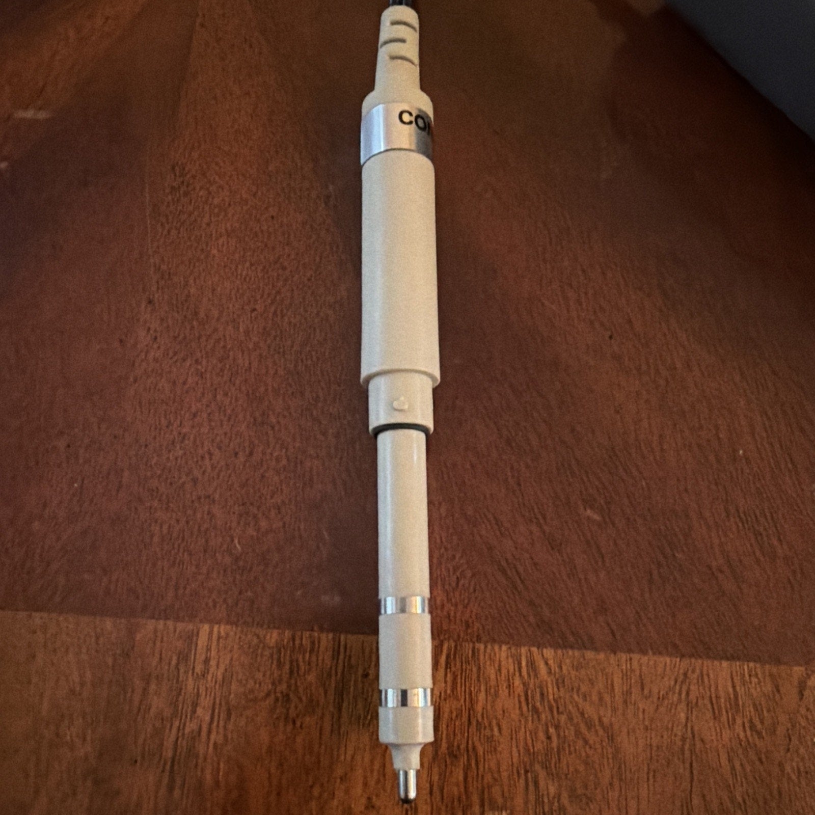 Oakton SALT 6+ handheld probe for measuring salinity with white body and silver metal accents on wood surface