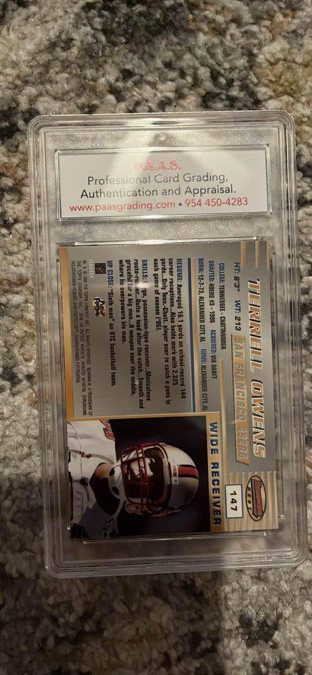 Terrell Owens football trading card graded and authenticated by PAAS, featuring player stats and photo in protective case